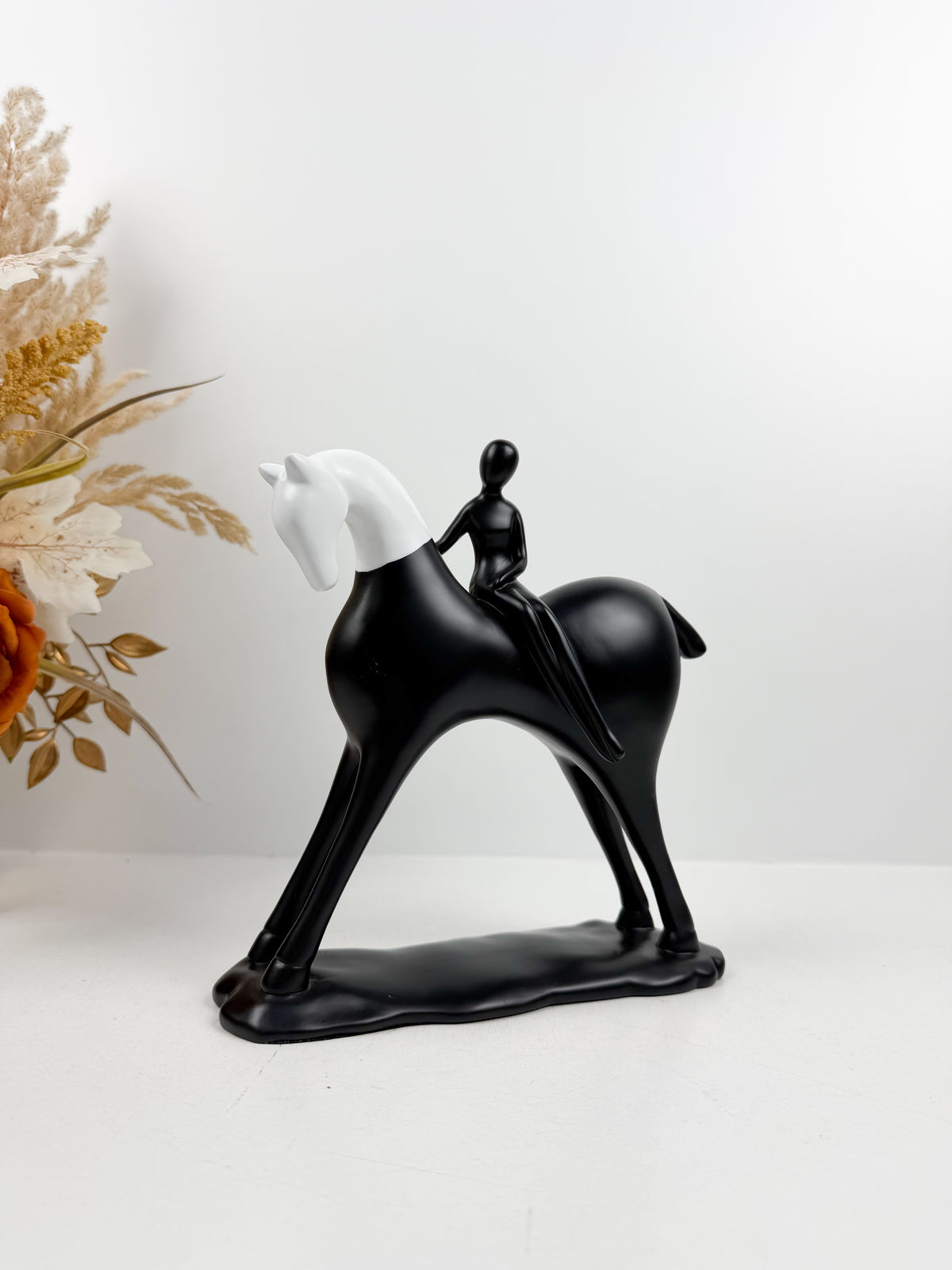 Sculpture décorative équestre moderne en noir et blanc représentant un cavalier stylisé sur son cheval.