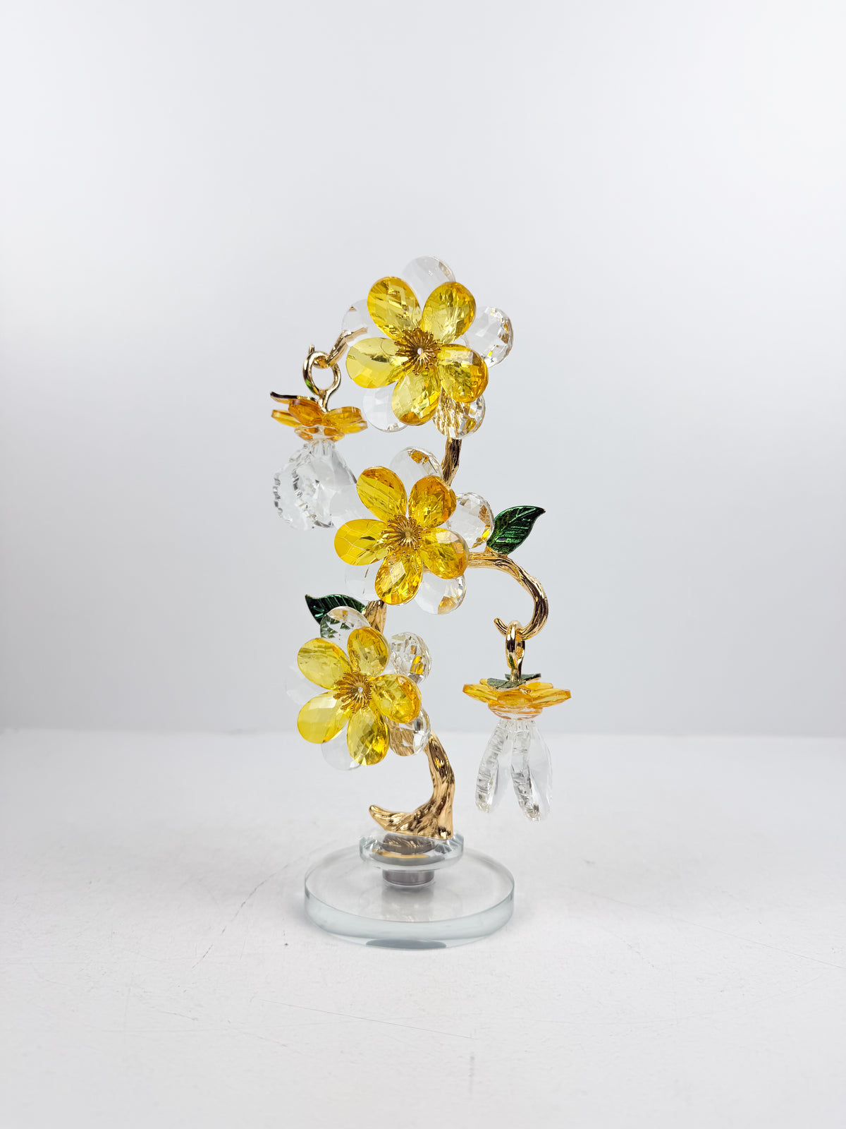 Sculpture d'arbre décoratif avec fleurs et cristaux dorés.