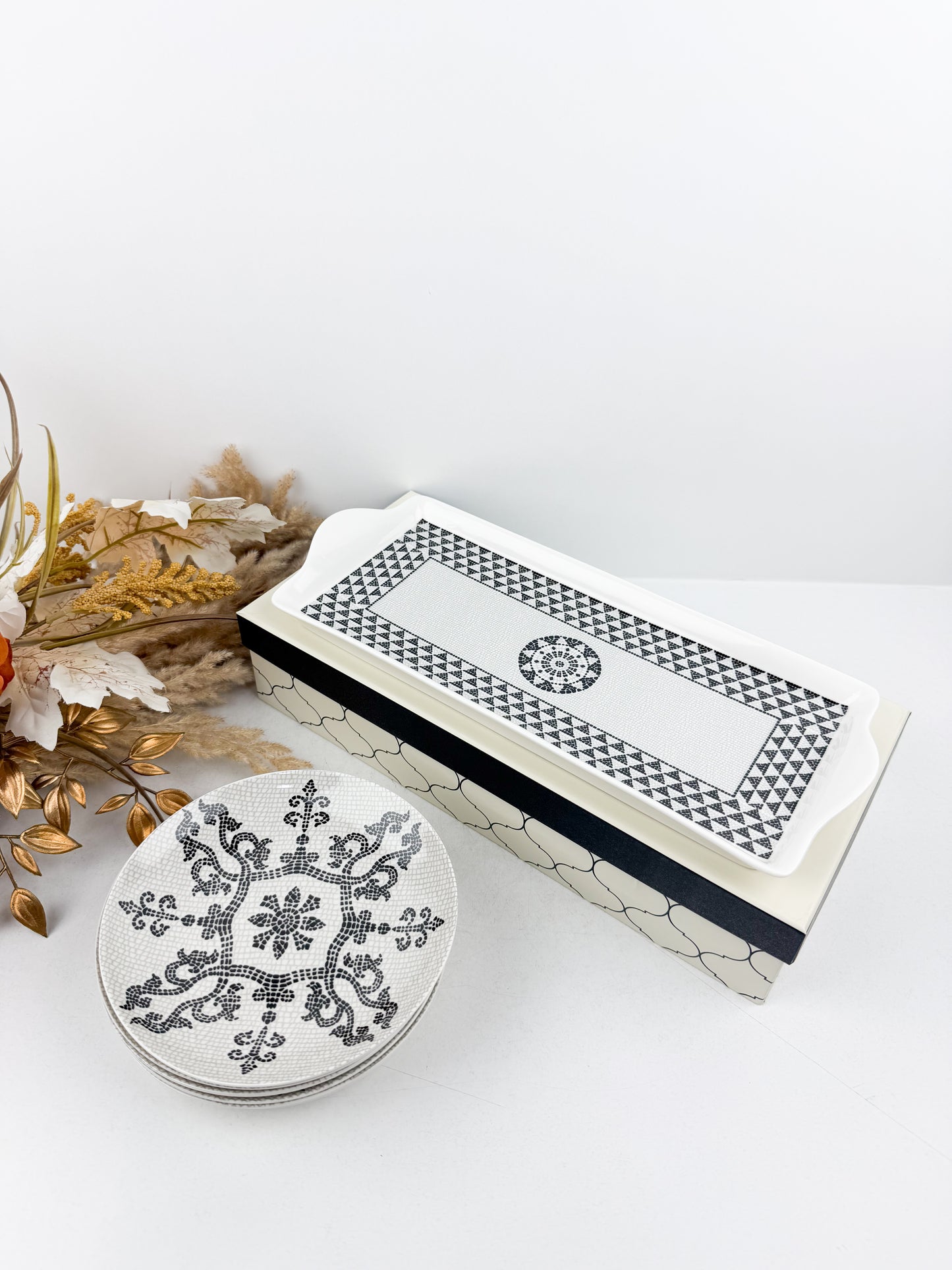 Ensemble de service élégant d'une grande assiette de présentation et de six assiettes assorties ornées en noir et blanc