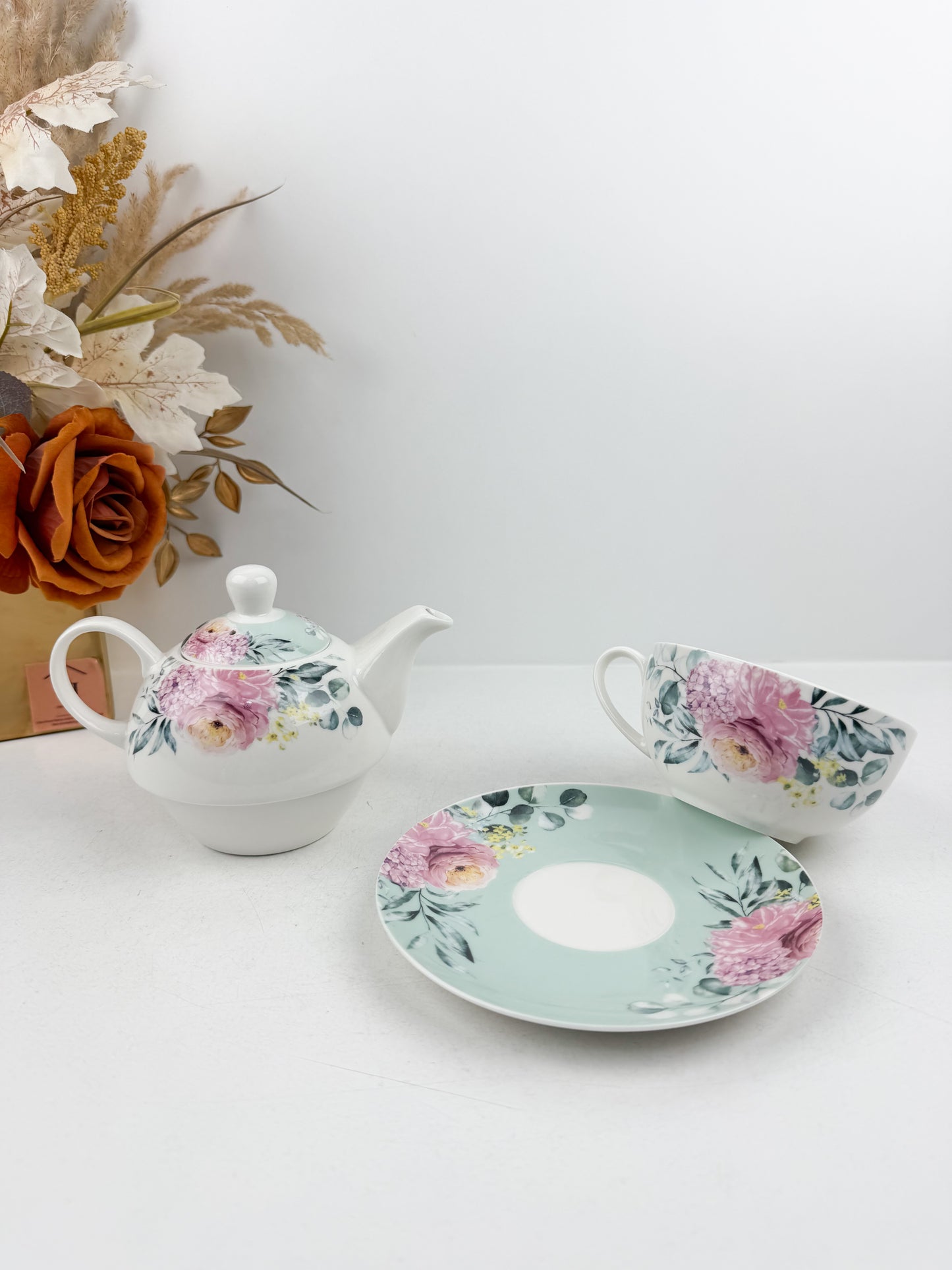 Théière élégante d'une tasse accompagnée de sous-tasse raffinée de motif floral