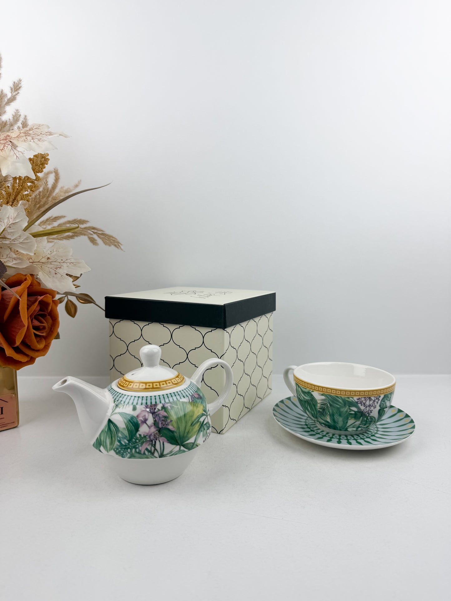Théière élégante d'une tasse accompagnée de sous-tasse raffinée de motif jungle