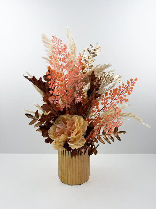 Fleurs séchées rehaussée d'une fleur rose délicate dans un vase en céramique doré aux lignes épurées