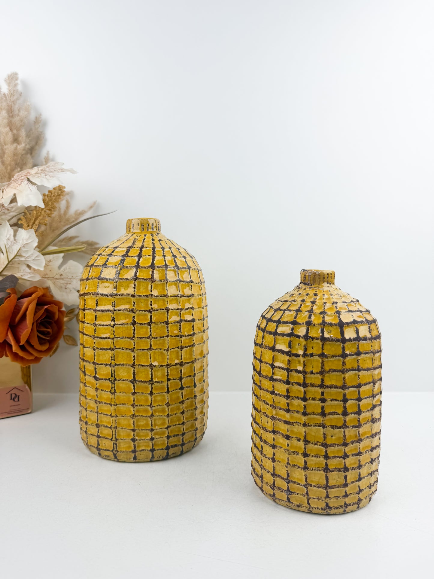 Duo de vases artisanal en céramique motif quadrillé jaune et noir.