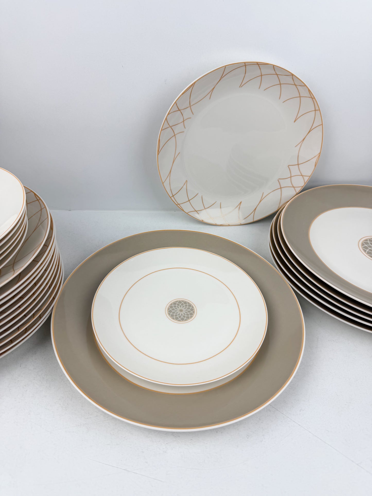 Service de table composé de 36 assiettes en porcelaine de luxe aux motifs élégants beige.
