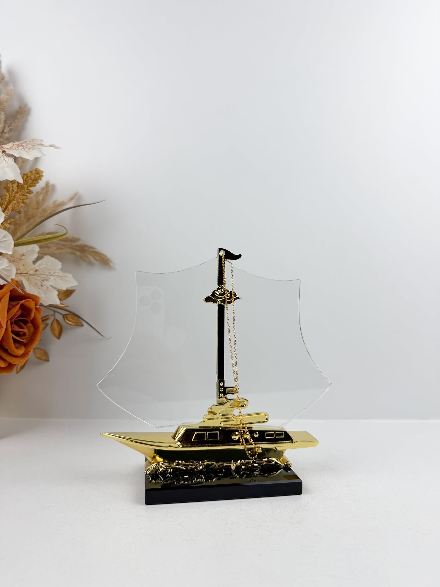 Bateau décoratif doré reposant sur un élégant socle noir