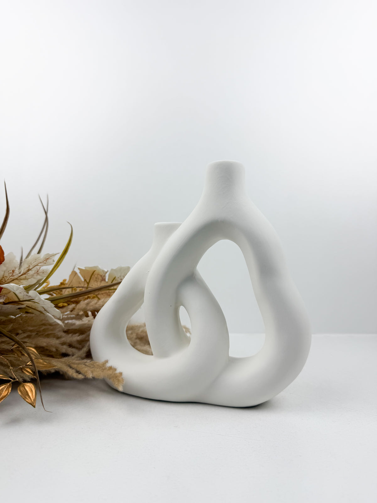 Vase blanc aux formes sculpturales et épurées pour un style moderne et raffiné.