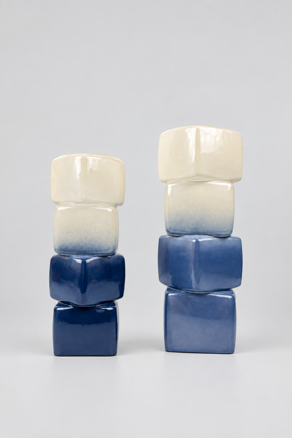 Duo de vases décoratifs géométriques au dégradé bleu et blanc.