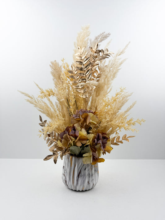 Fleurs séchés marron d'une élégance intemporelle dans un vase en forme de marbre raffiné.