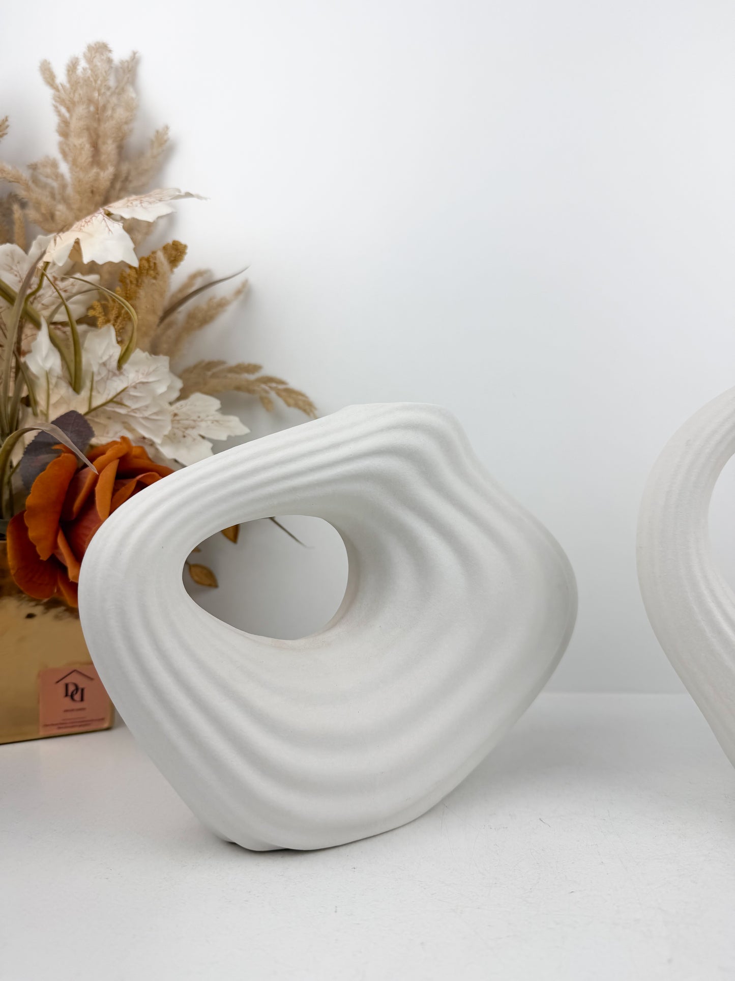 Duo de vases en céramique blanc mat aux formes géométriques épurées.