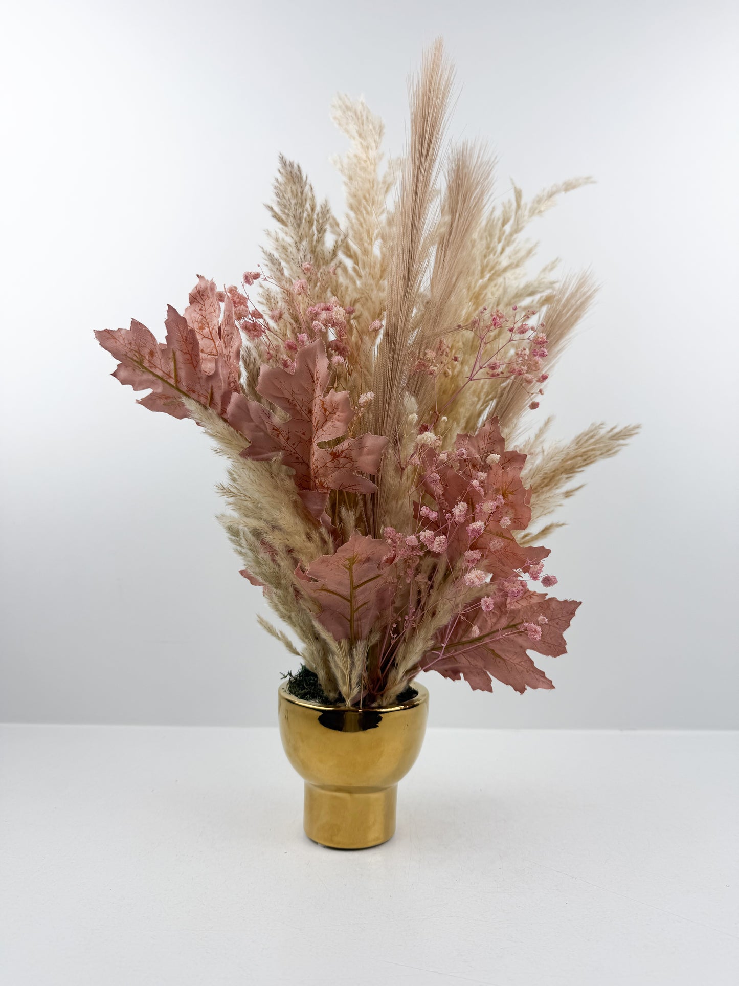 Fleurs séchées violet élégant arrangées dans un vase doré très chic.
