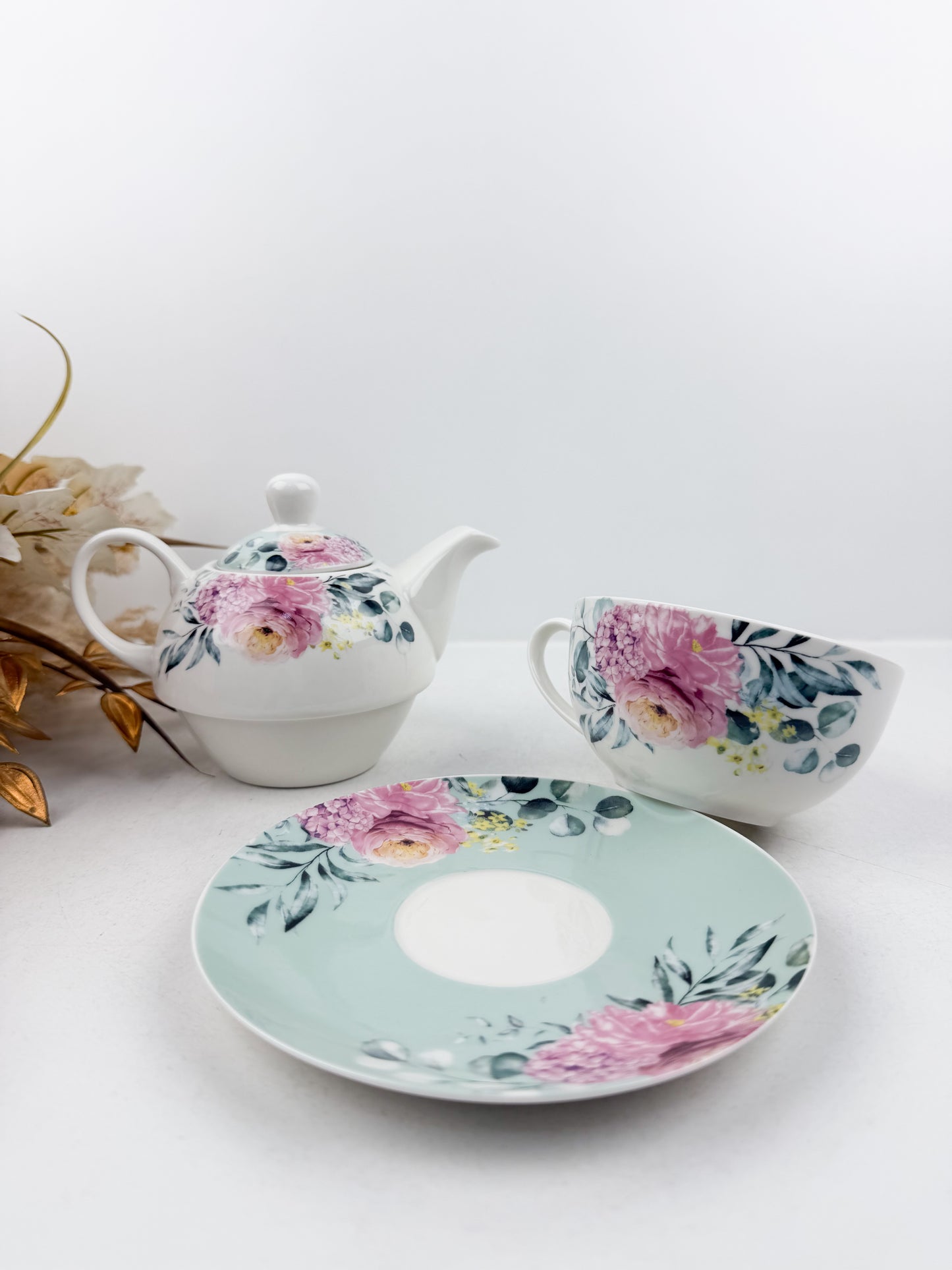 Théière élégante d'une tasse accompagnée de sous-tasse raffinée de motif floral