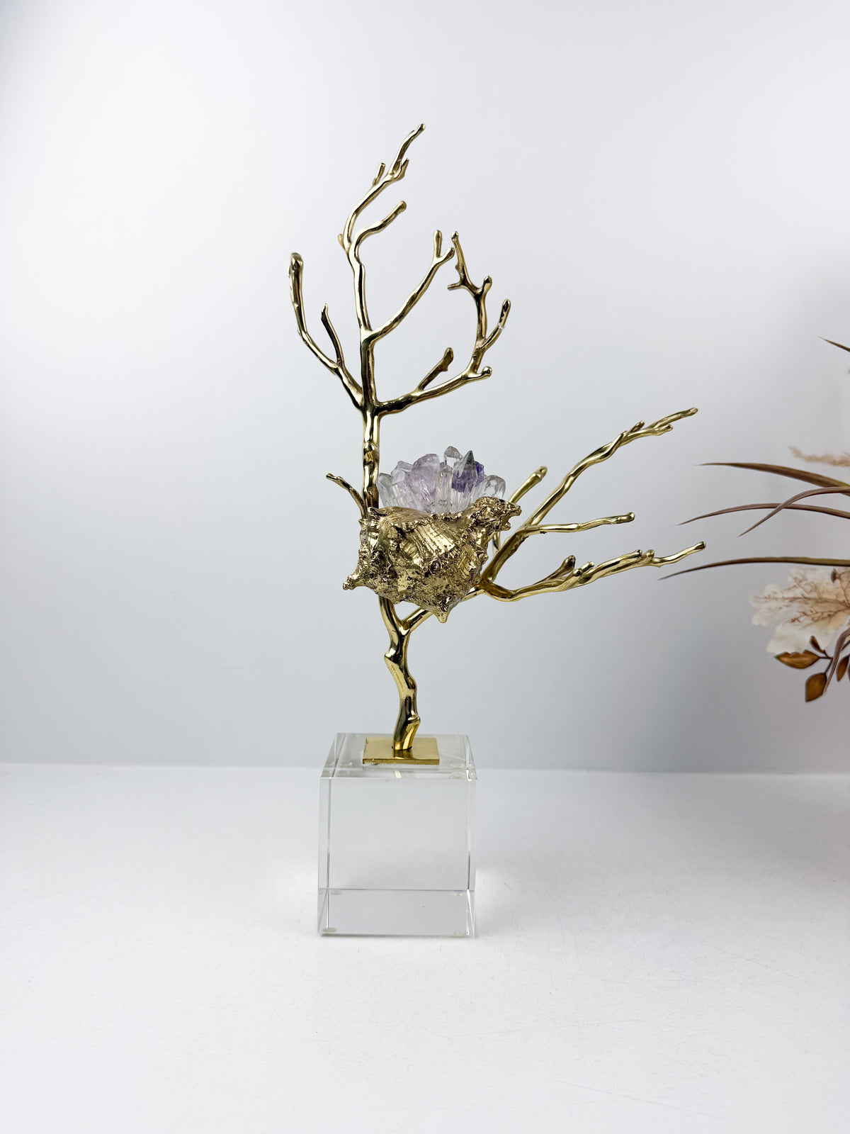 Sculpture de luxe de forme coquillage alliant l'élégance intemporelle du laiton doré aux reflets captivants des cristaux naturels.