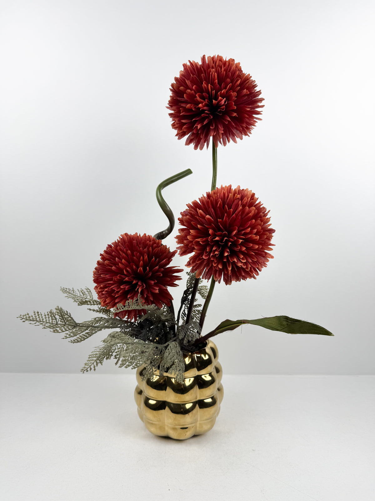 Fleurs artificielles élégantes en forme de pompons rouges élégantes.
