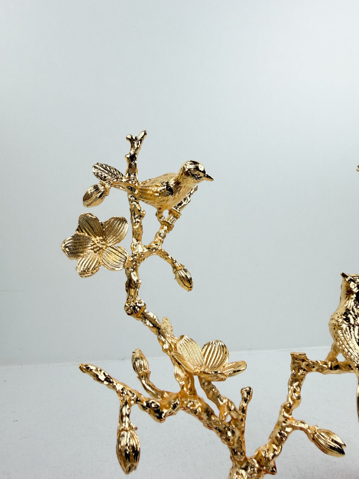 Sculpture décorative d'un arbre aux oiseaux en métal doré.