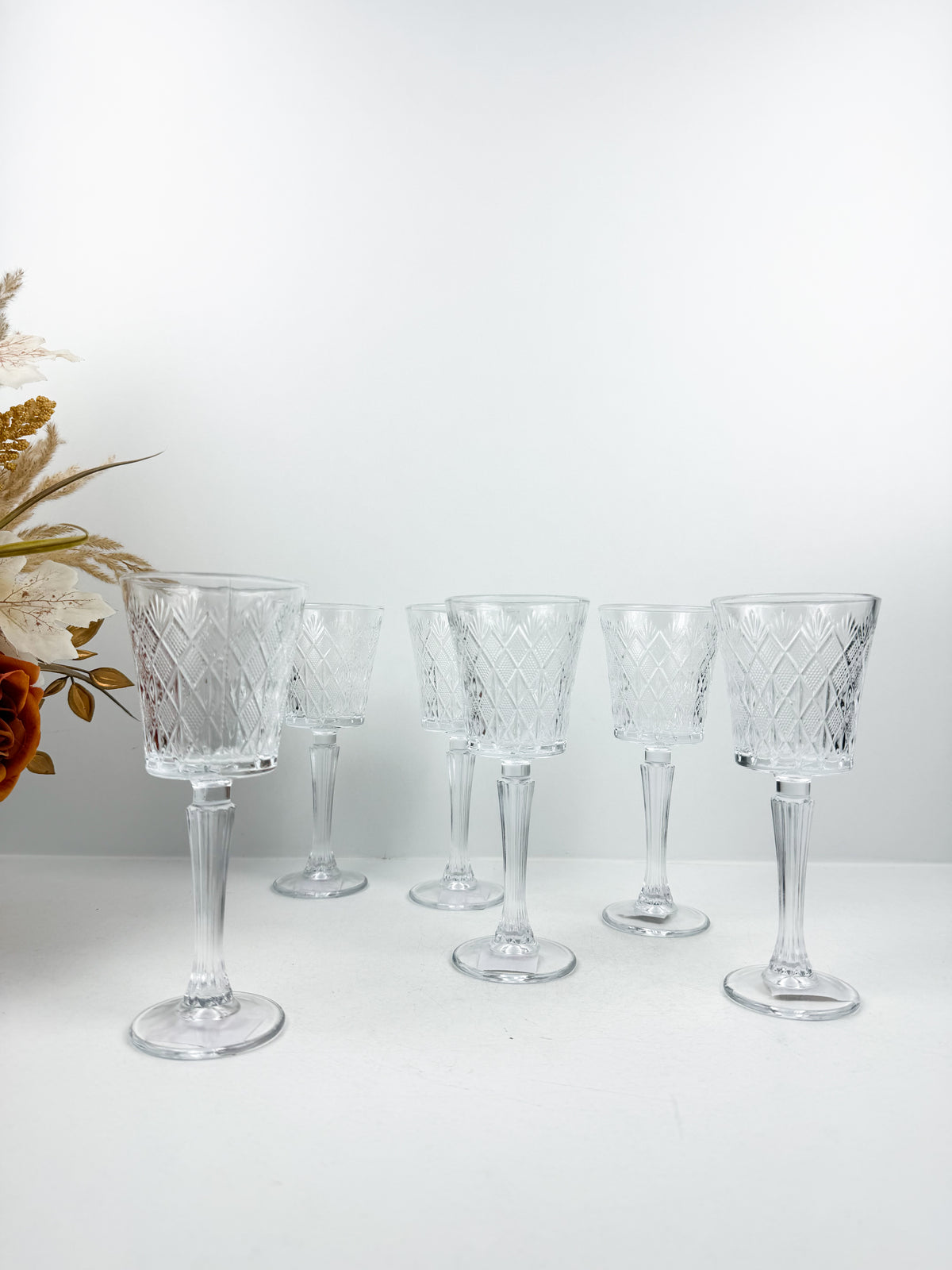 Ensemble de six verres à pied transparents en verre sculpté et ciselé à motifs géométriques.