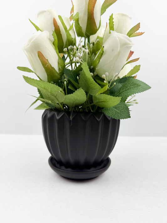 Fleurs artificielles blanches d'une élégance intemporelle dans un vase noir aux finitions impeccables.