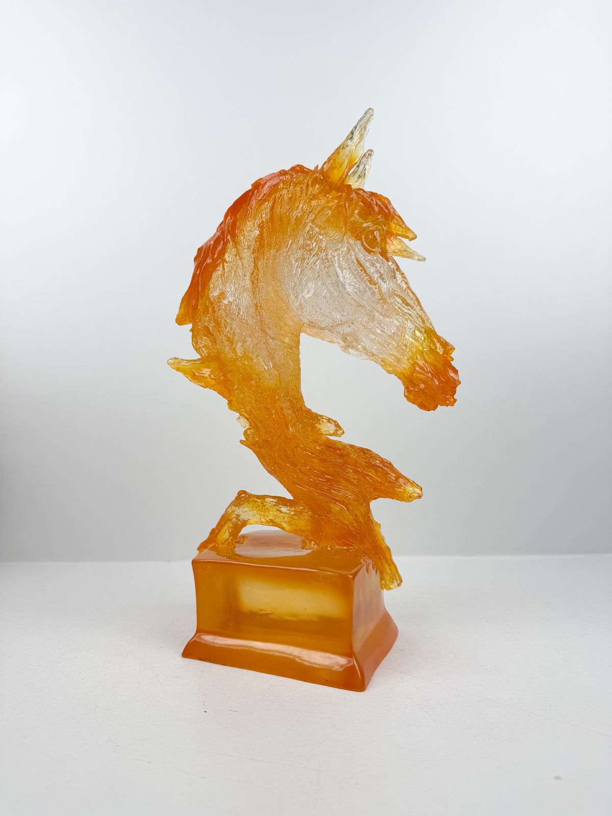 Sculpture tête de cheval en résine ambrée.