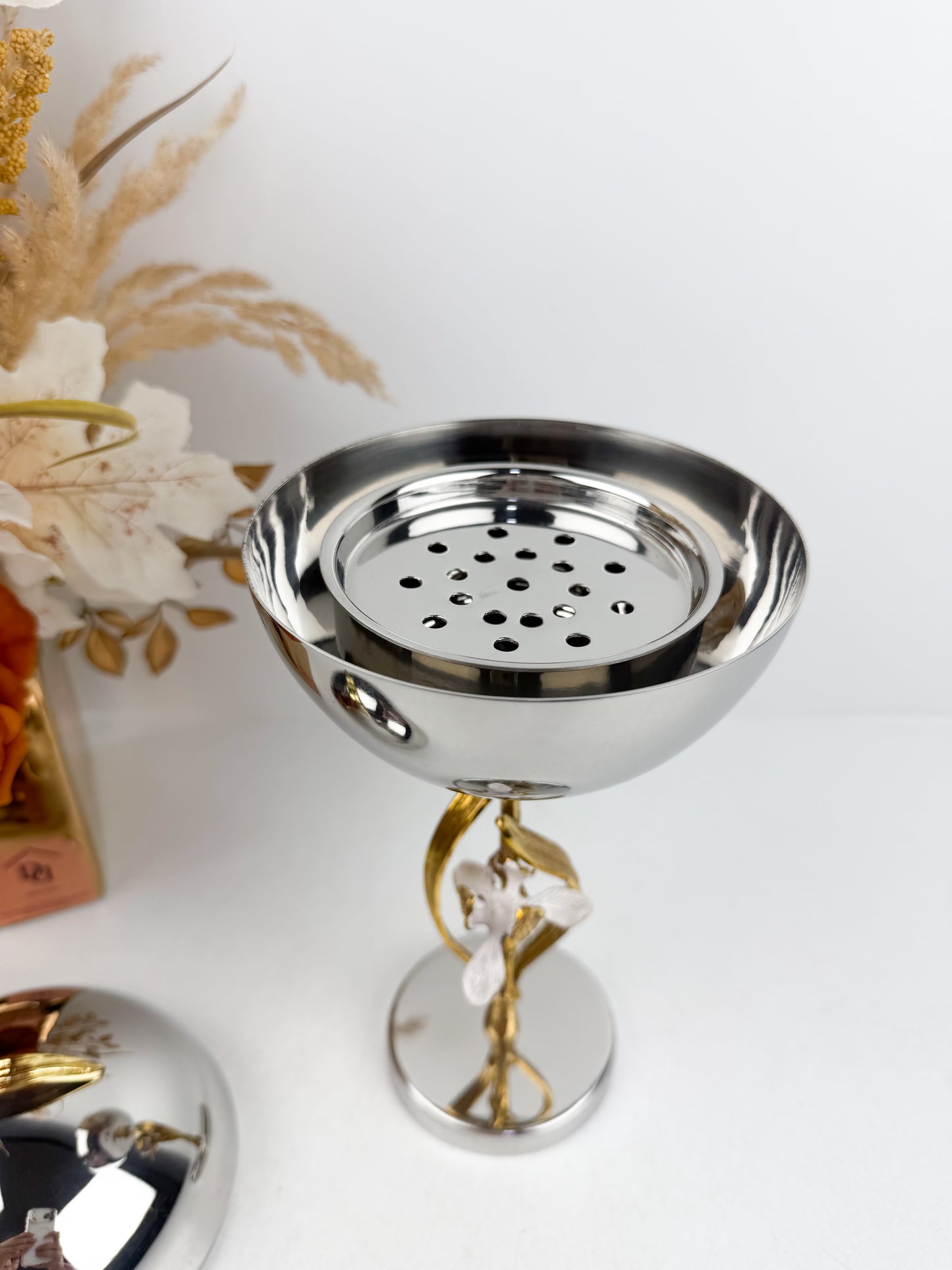 Ensemble de brûleur d'encens élégant en métal argenté de détails floraux.