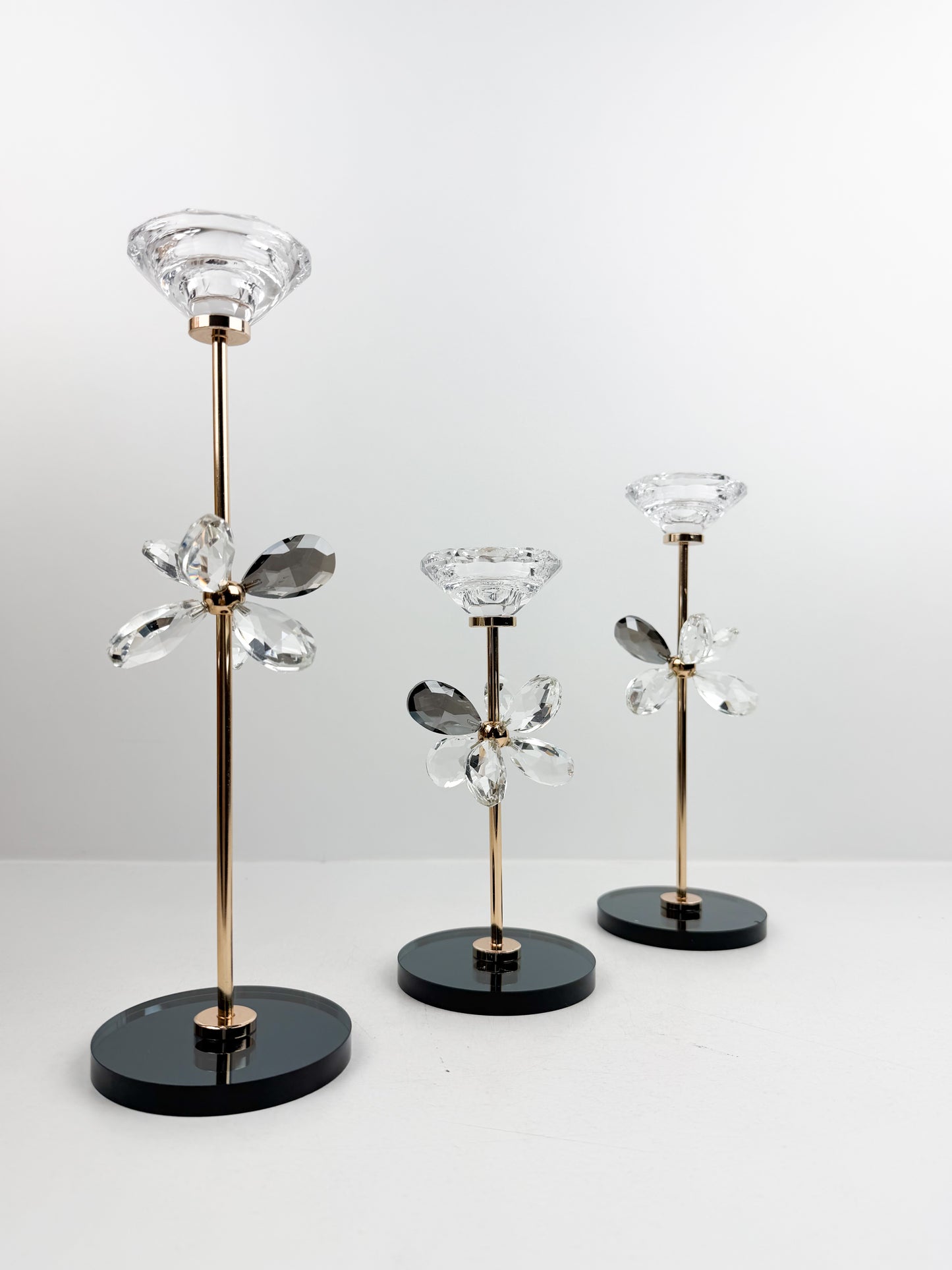 Trio de Bougeoirs contemporain fleur en cristal sur un socle noir.