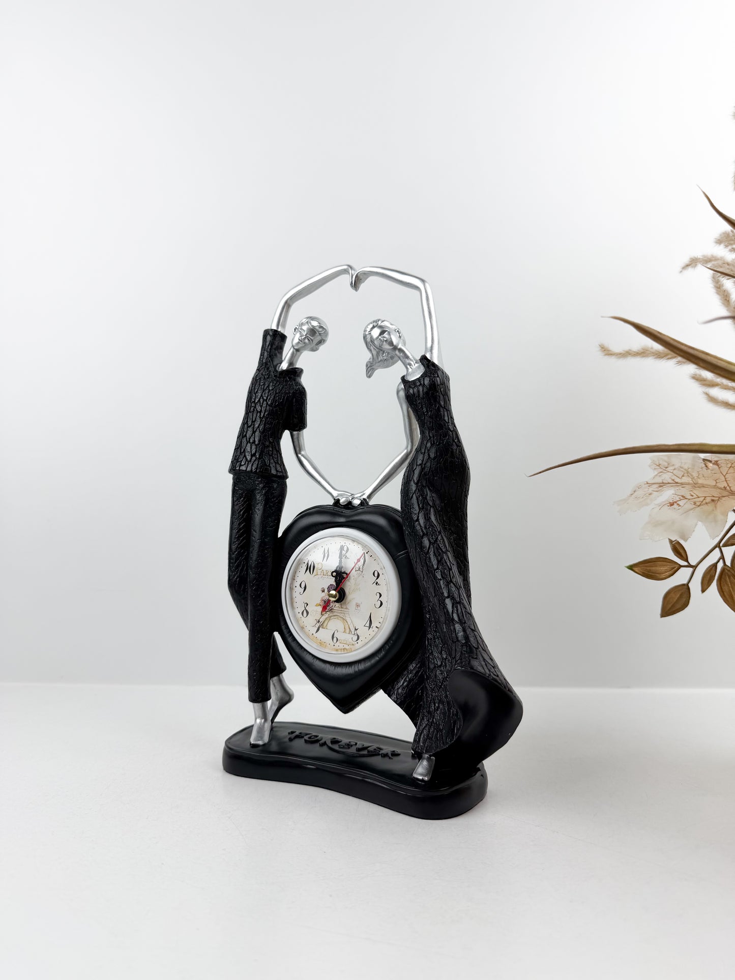 Horloge élégante ornée d'un couple décoratif intemporel