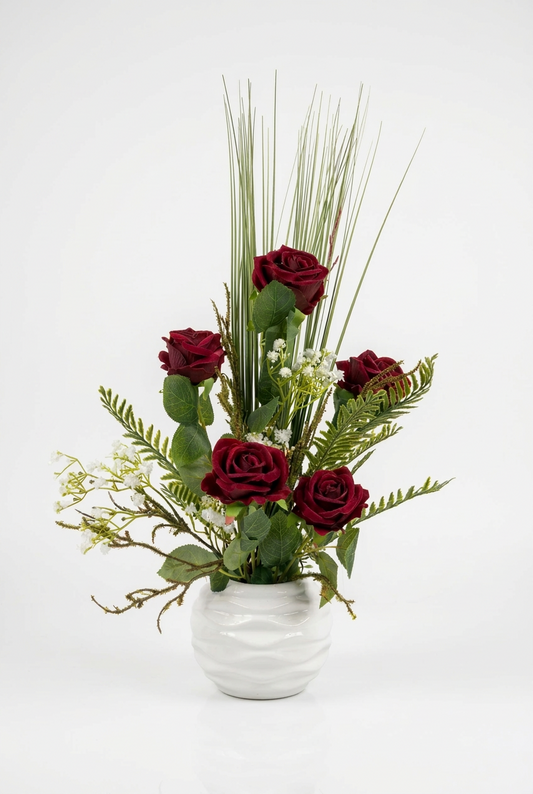 Fleurs séchées rouges délicate dans un vase en céramique aux lignes épurées.