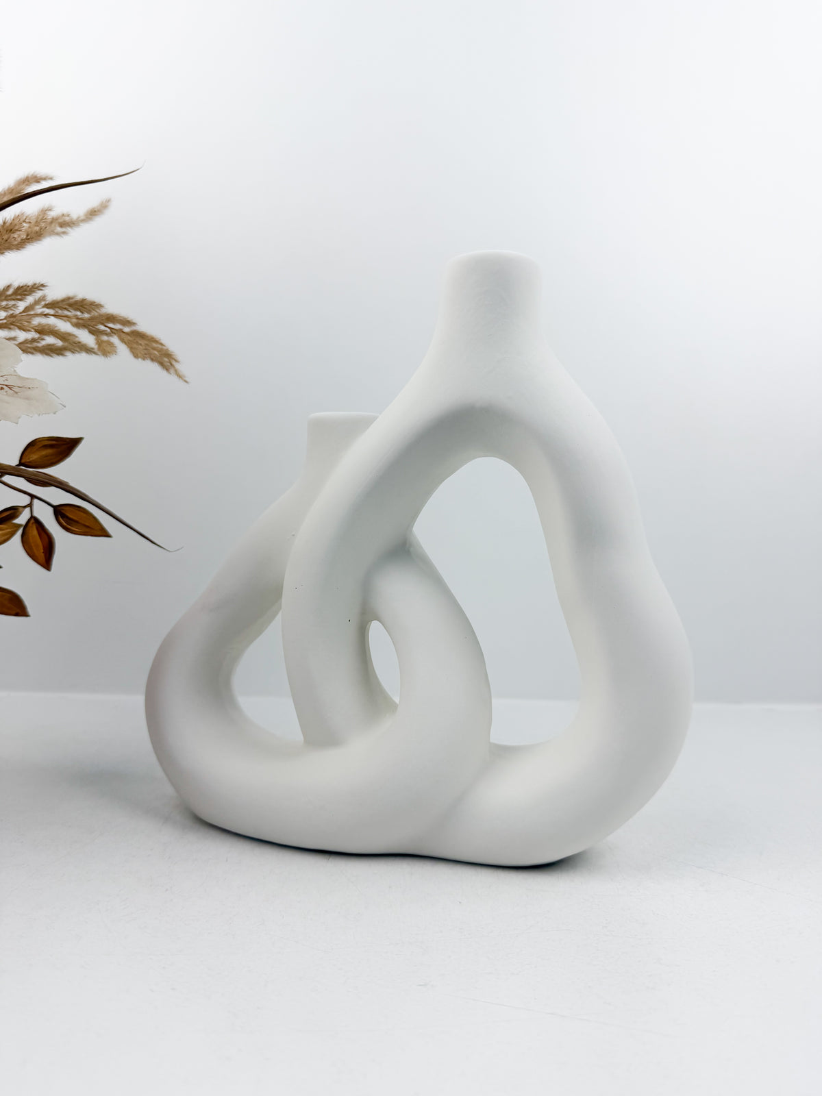 Vase blanc aux formes sculpturales et épurées pour un style moderne et raffiné.