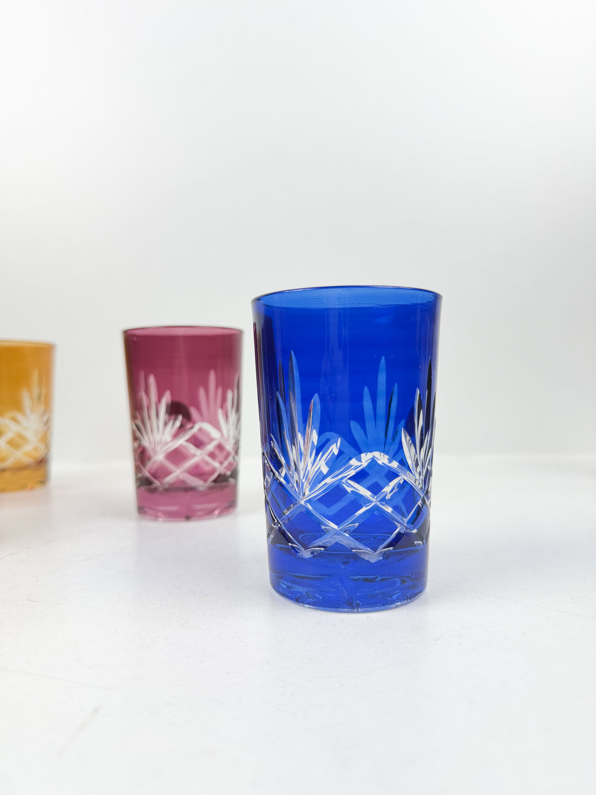 Ensemble de six verres à thé traditionnels en cristal de couleurs variées.