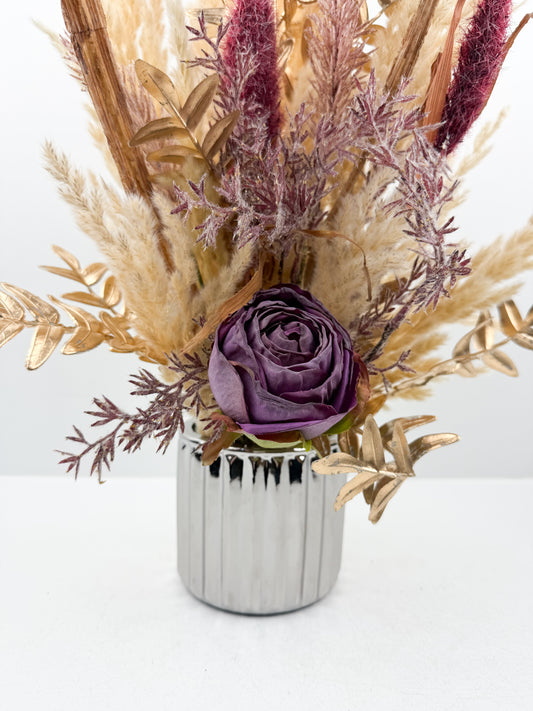 Fleurs séchées violet d'une élégance intemporelle dans un vase argenté aux finitions impeccables.