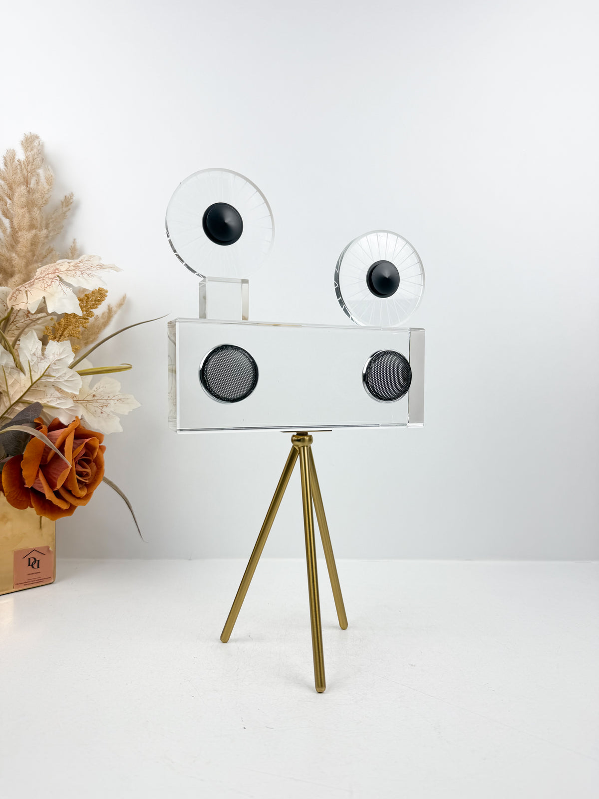 Projecteur caméra cinéma vintage sur trépied doré.