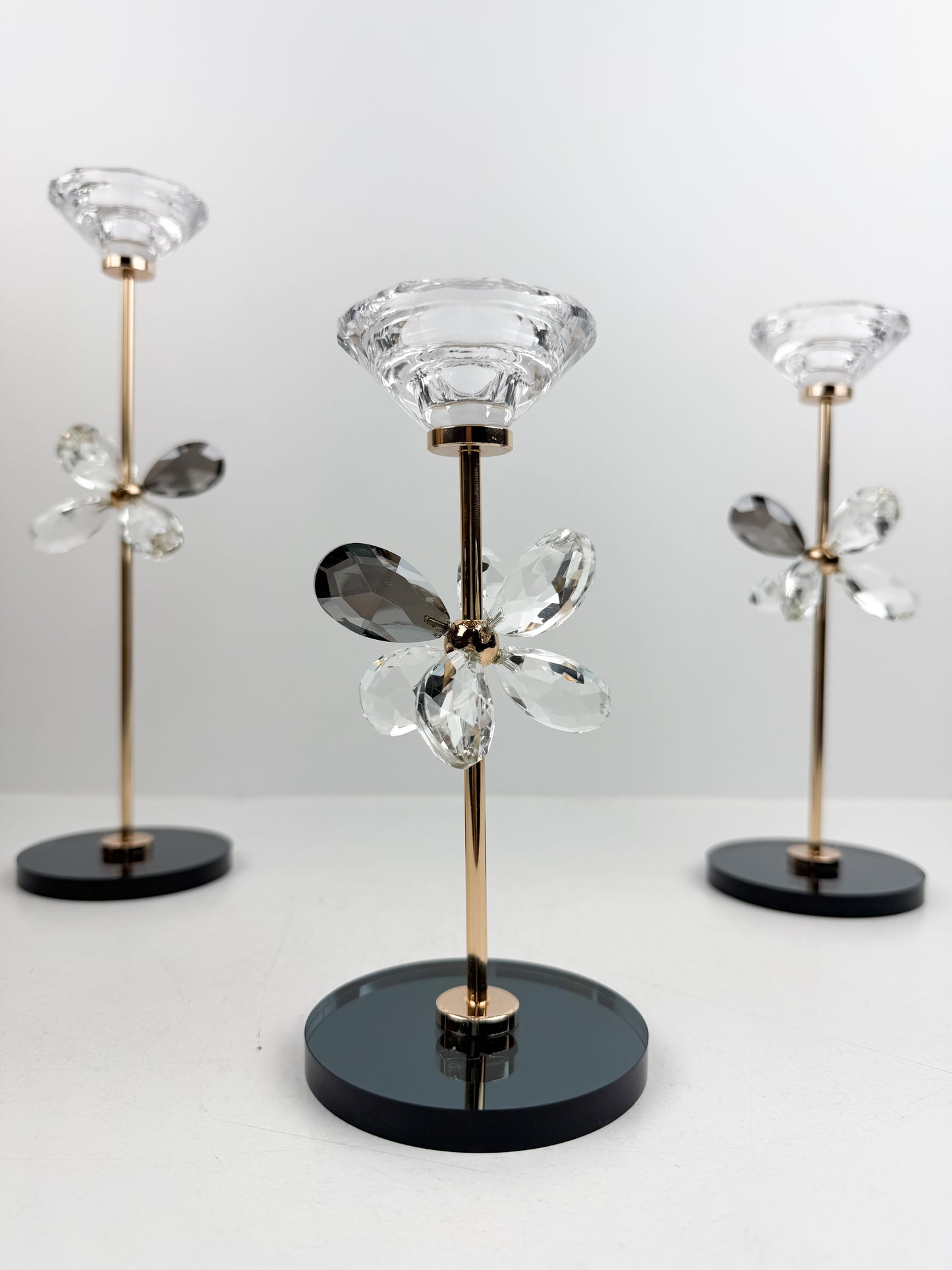 Trio de Bougeoirs contemporain fleur en cristal sur un socle noir.