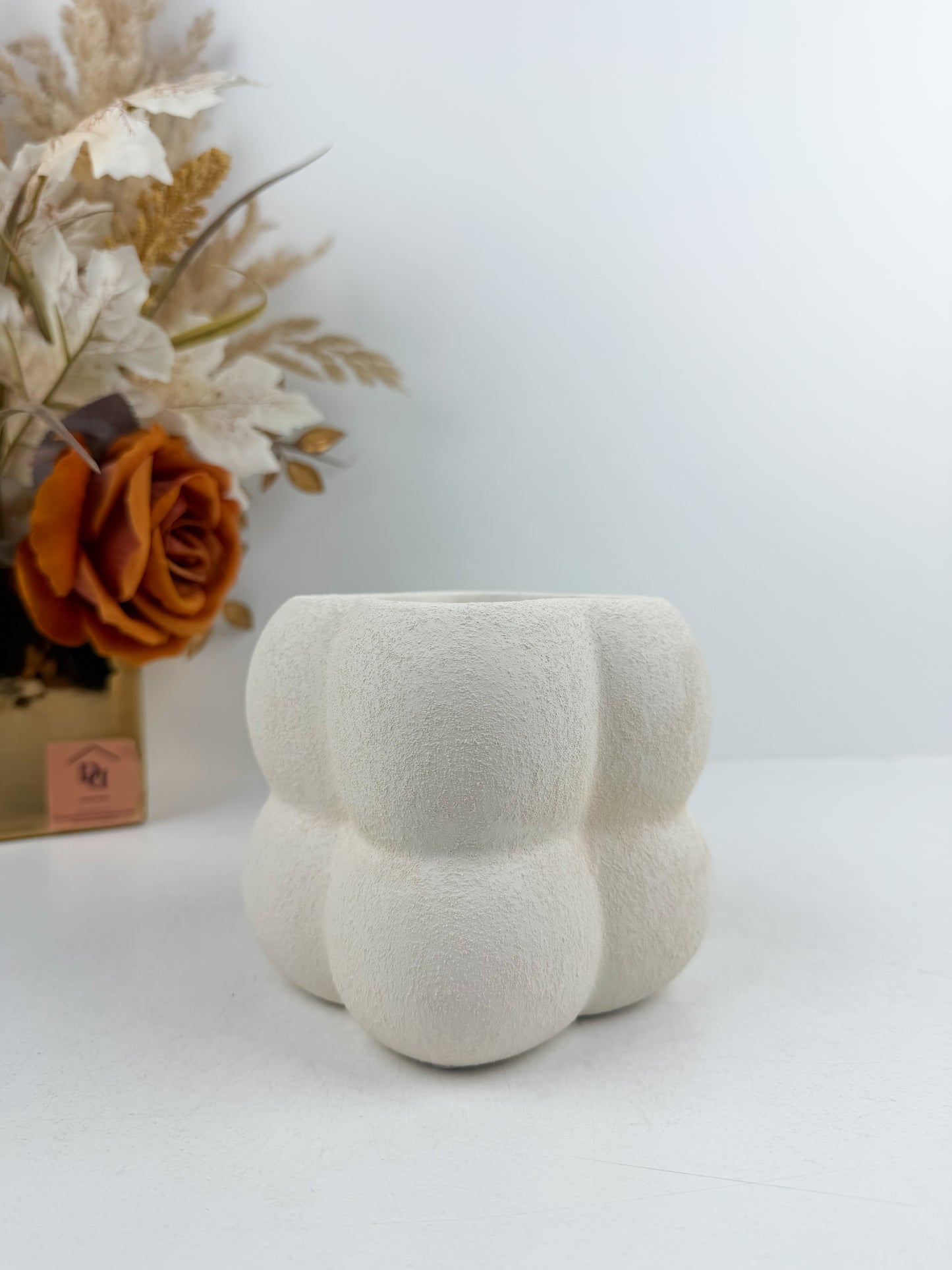 Petit vase en céramique blanc aux finitions texturées et bulles délicates.