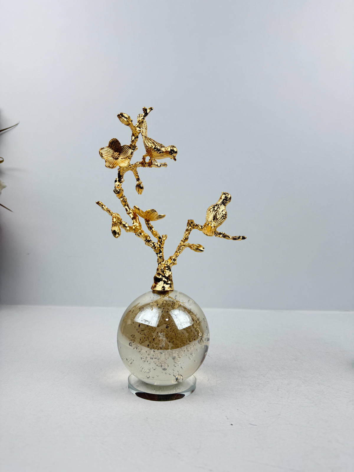 Sculpture décorative d'un arbre aux oiseaux en métal doré.