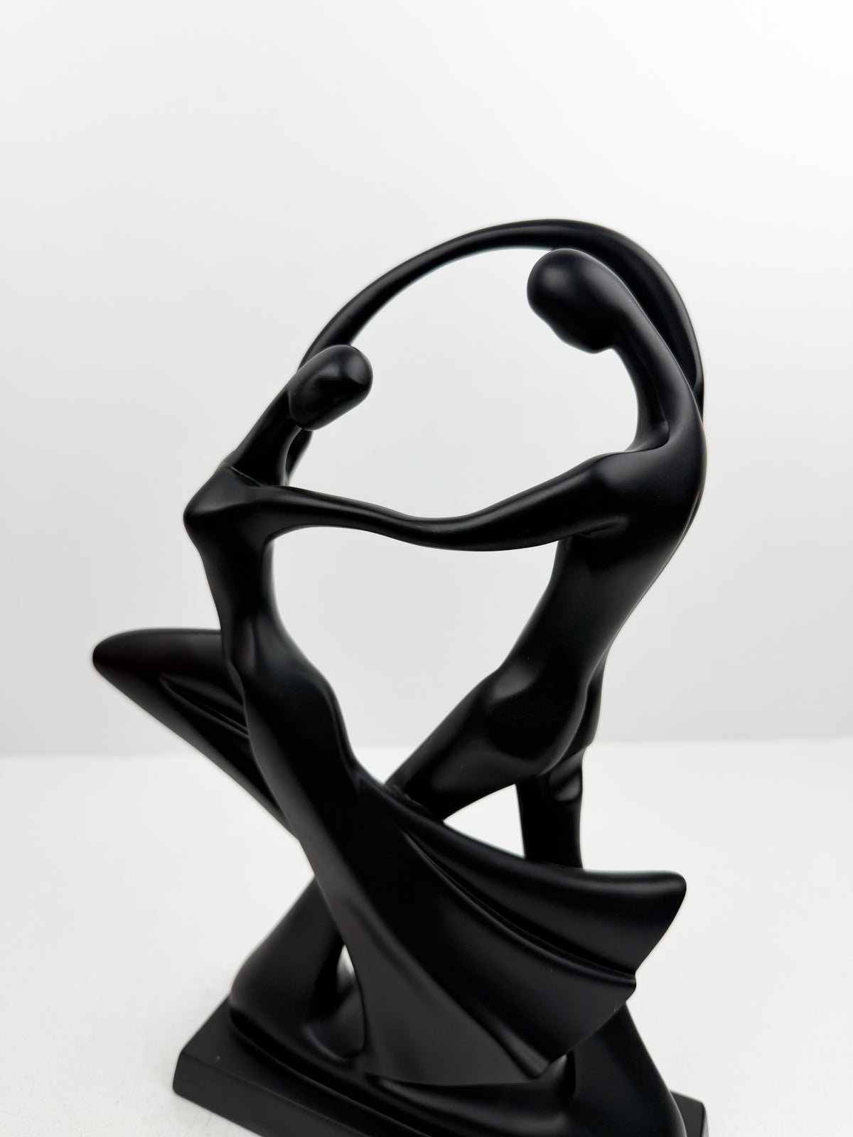 Duo de sculpture décorative entrelacées dans une posture de danse fluide et élégante.
