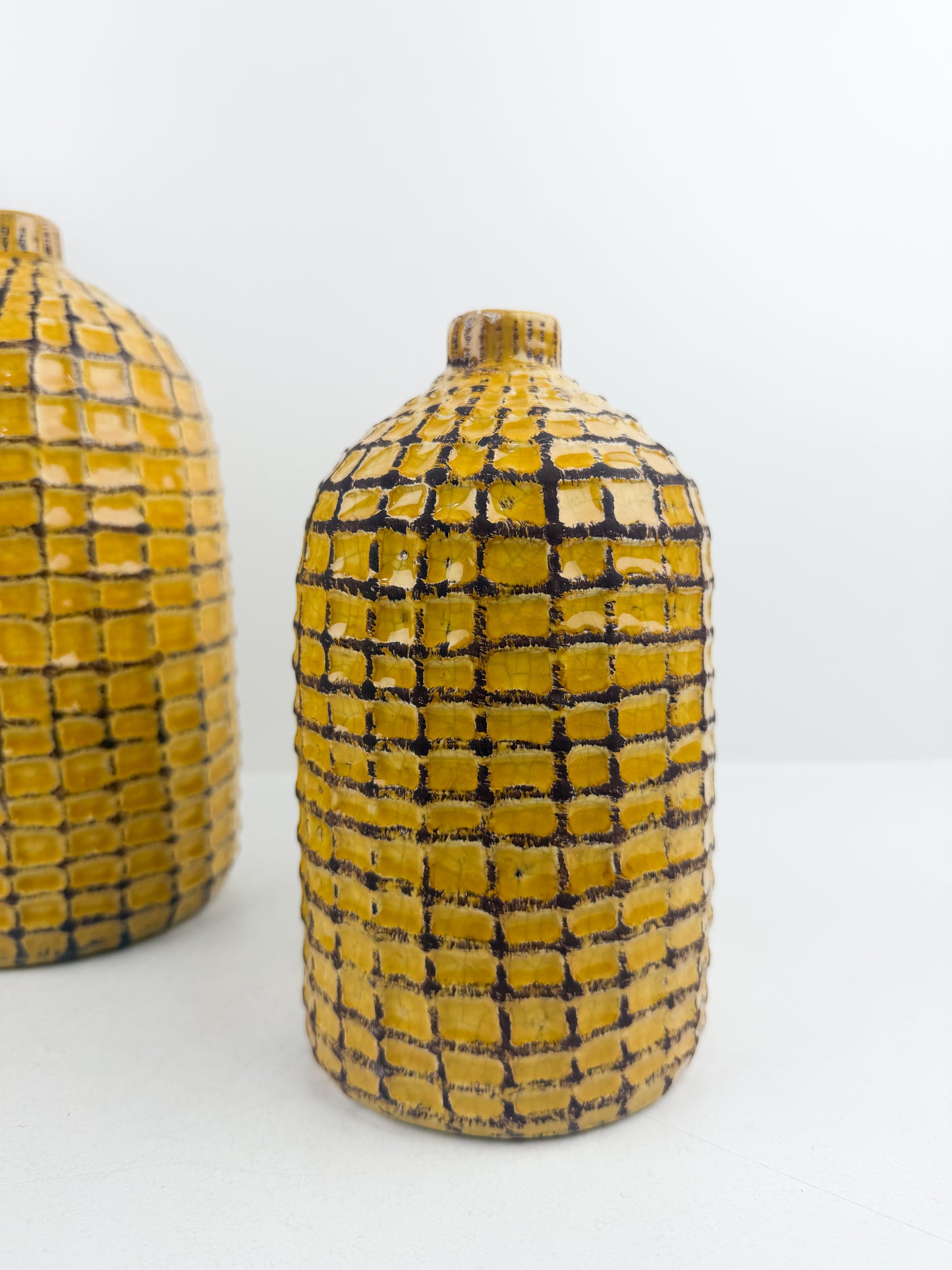 Duo de vases artisanal en céramique motif quadrillé jaune et noir.