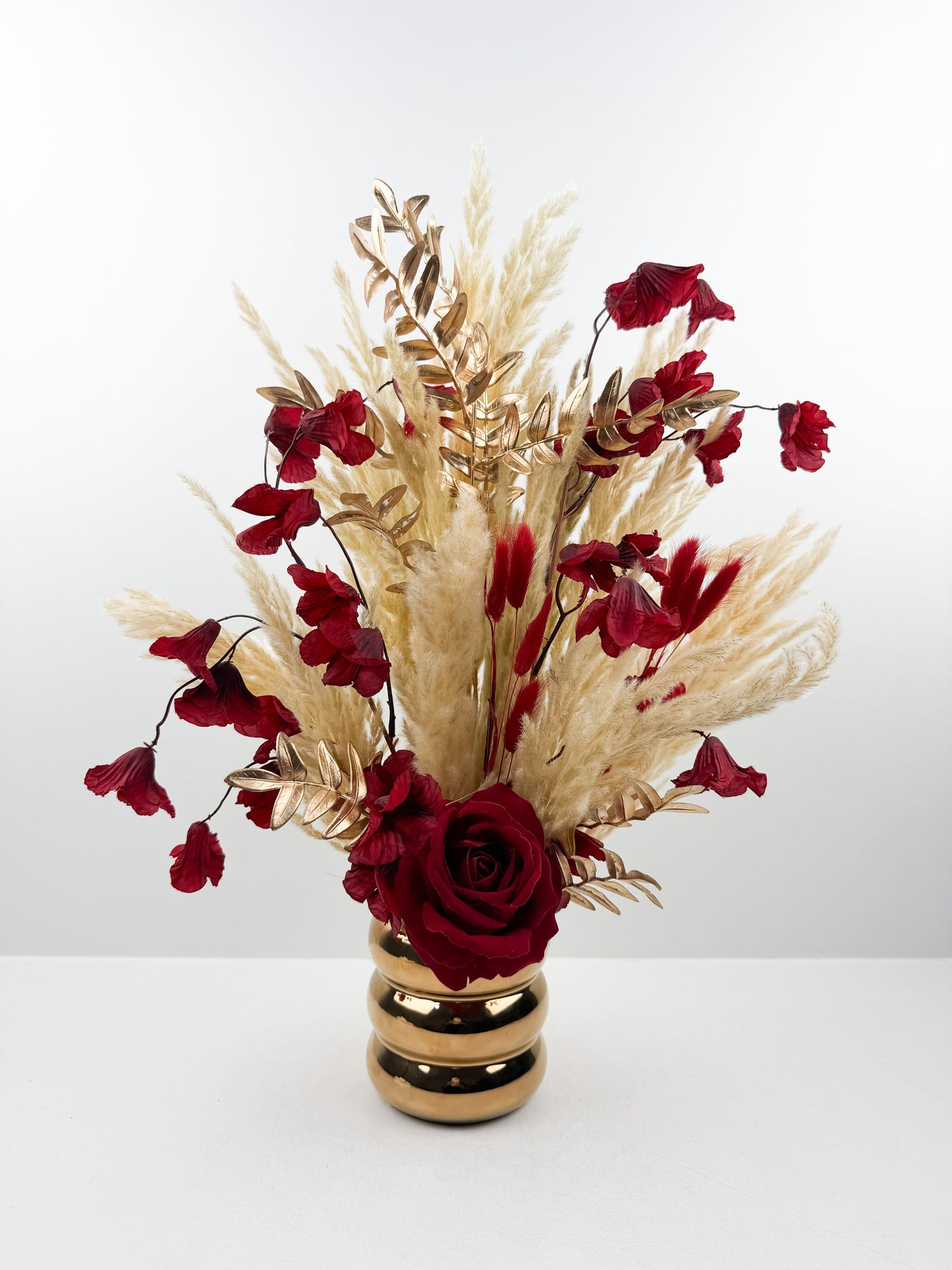 Fleurs séchées très chic aux teintes beiges naturelles par une délicate fleur rouge qui apporte une touche de couleur et d'élégance.