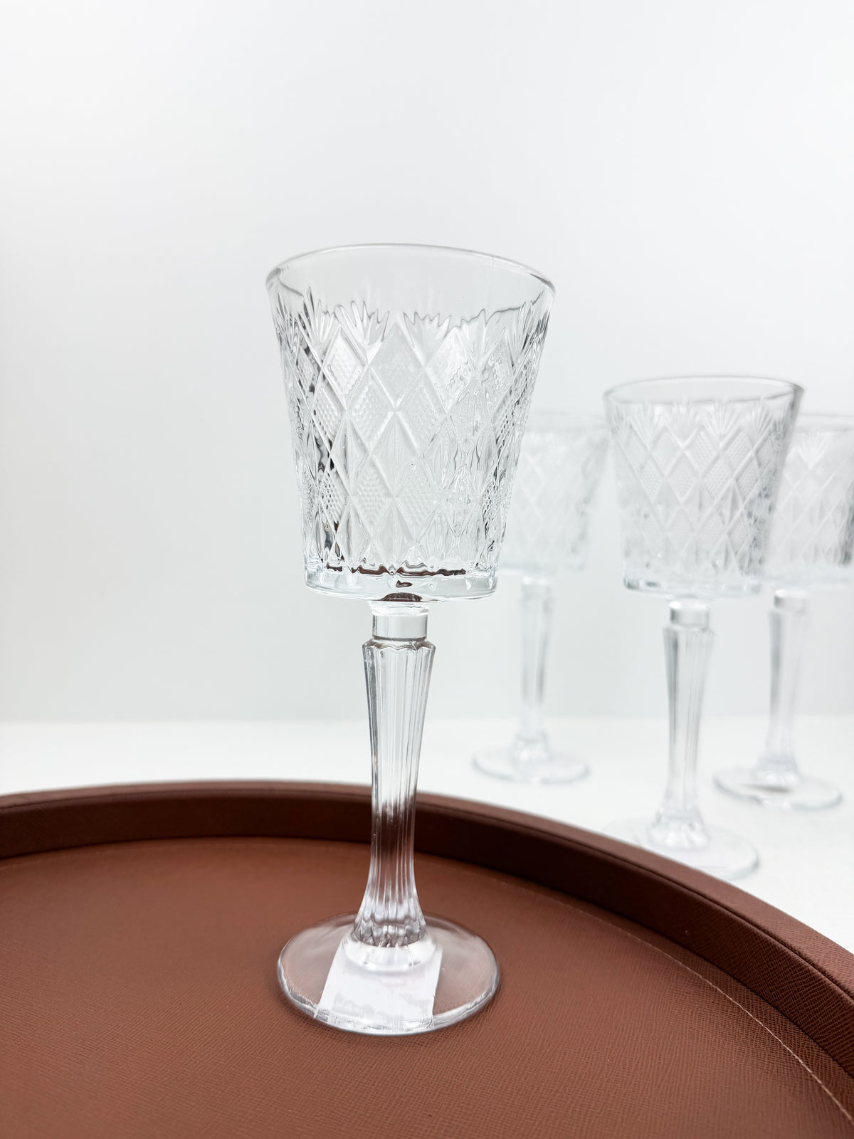 Ensemble de six verres à pied transparents en verre sculpté et ciselé à motifs géométriques.