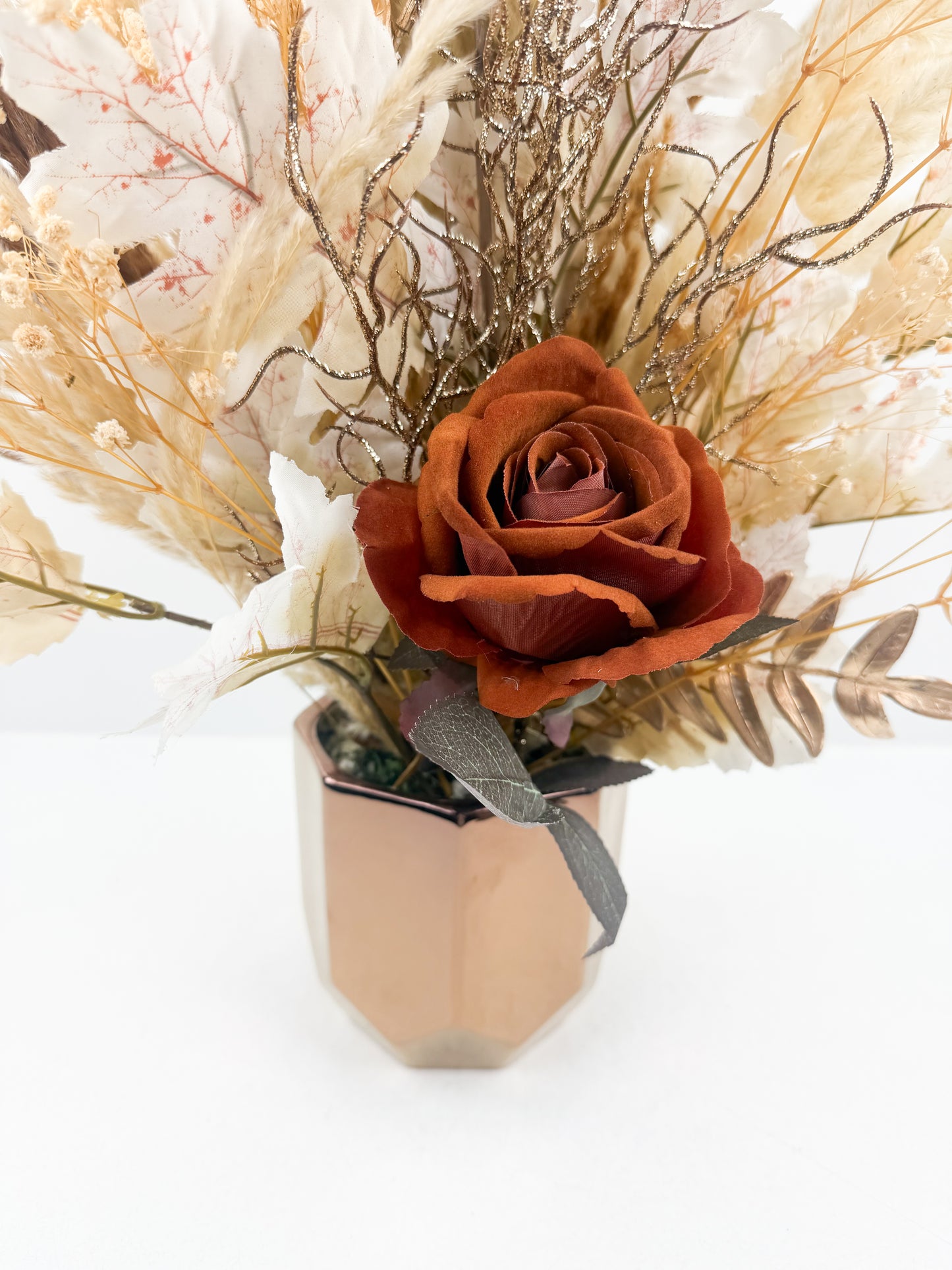 Fleurs séchées marron avec une fleure marron foncé luxe dans un pot en céramique bronze aux finitions miroir.