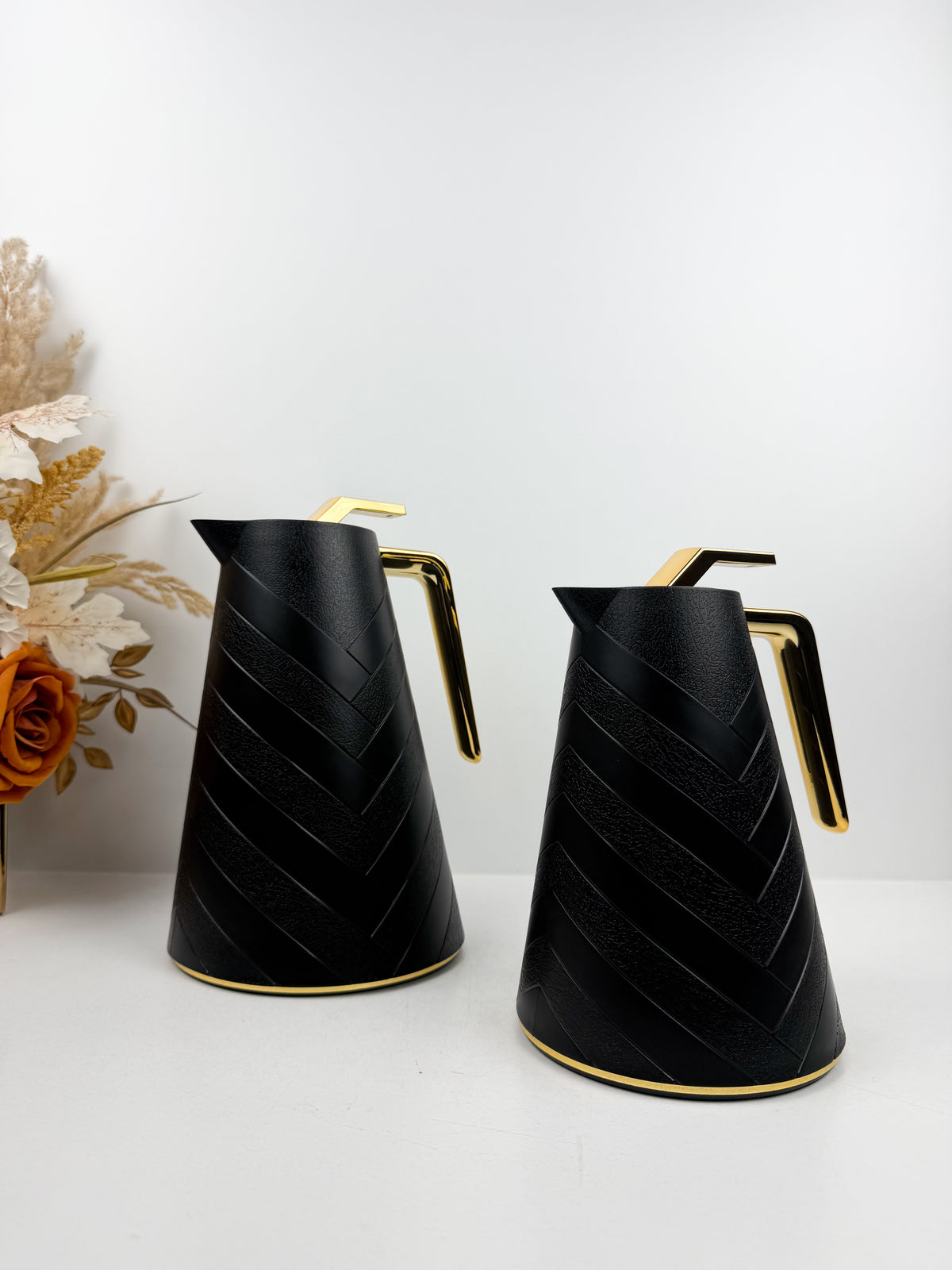 Duo de thermos isothermes noirs mats avec motifs chevrons en relief, anses et détails dorés.