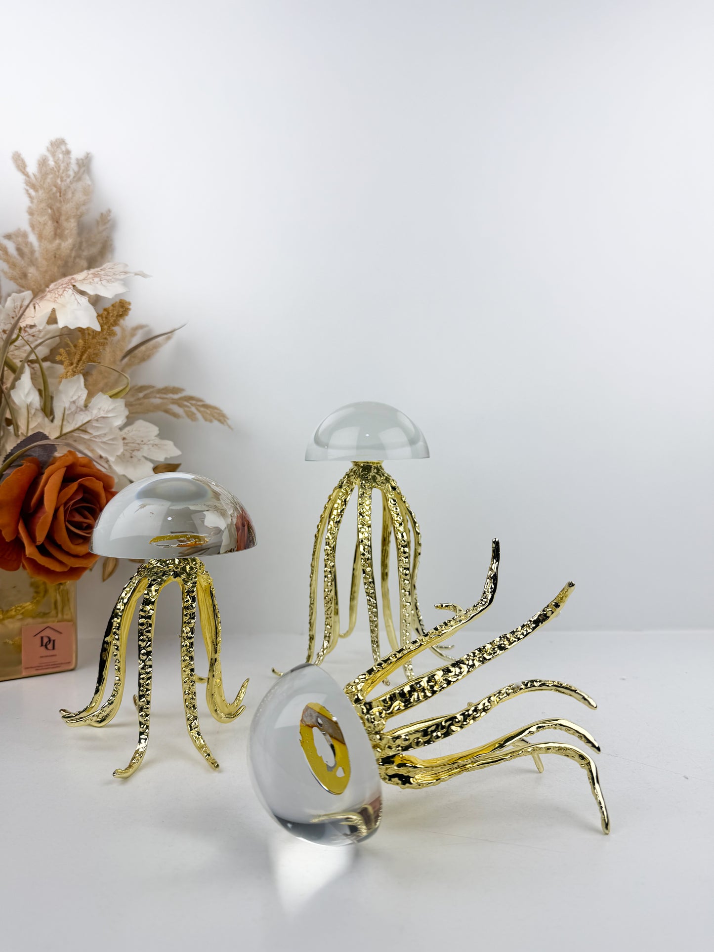 Trois sculptures de méduses dorées en métal avec un dôme en cristal