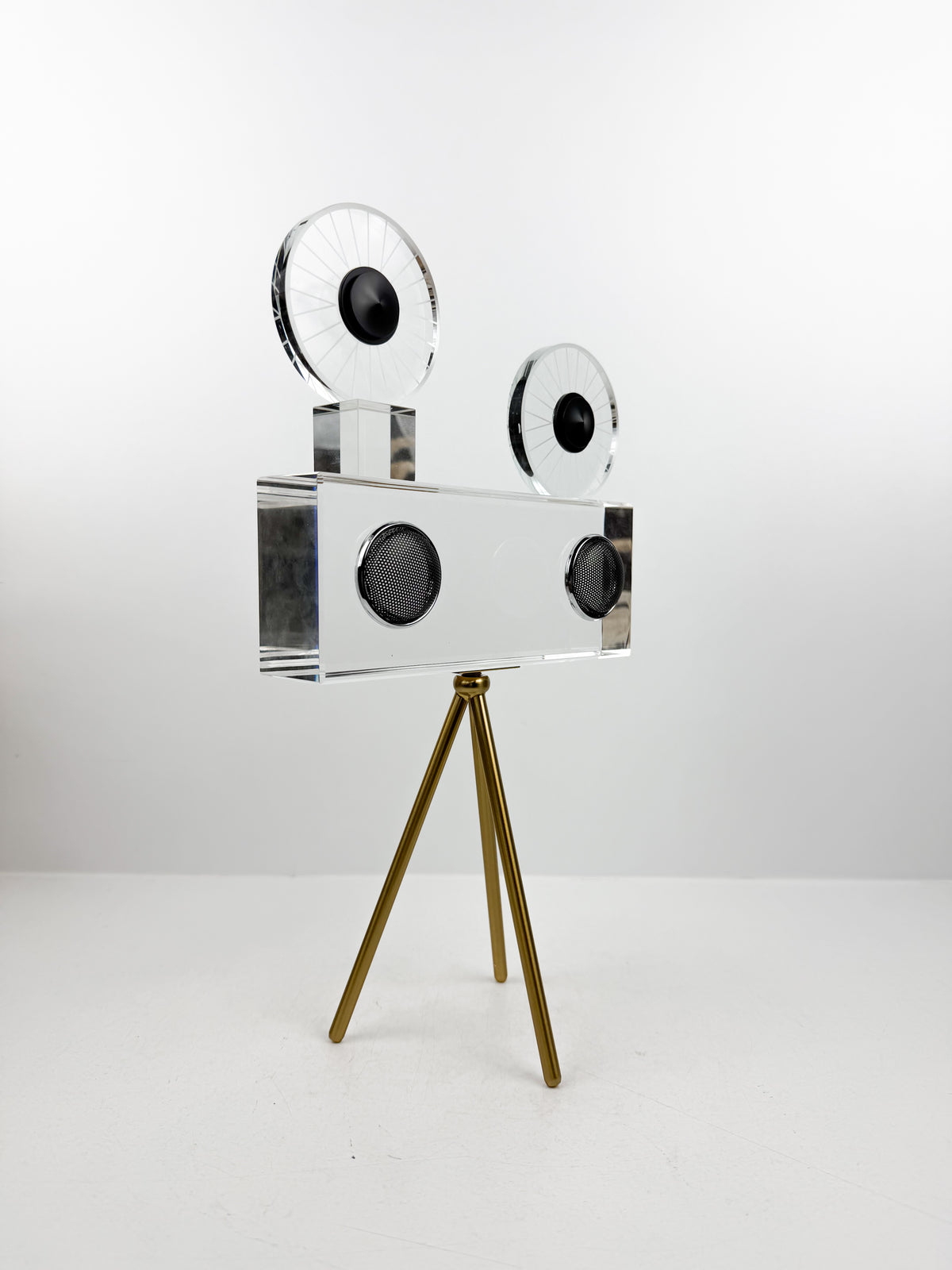 Projecteur caméra cinéma vintage sur trépied doré.
