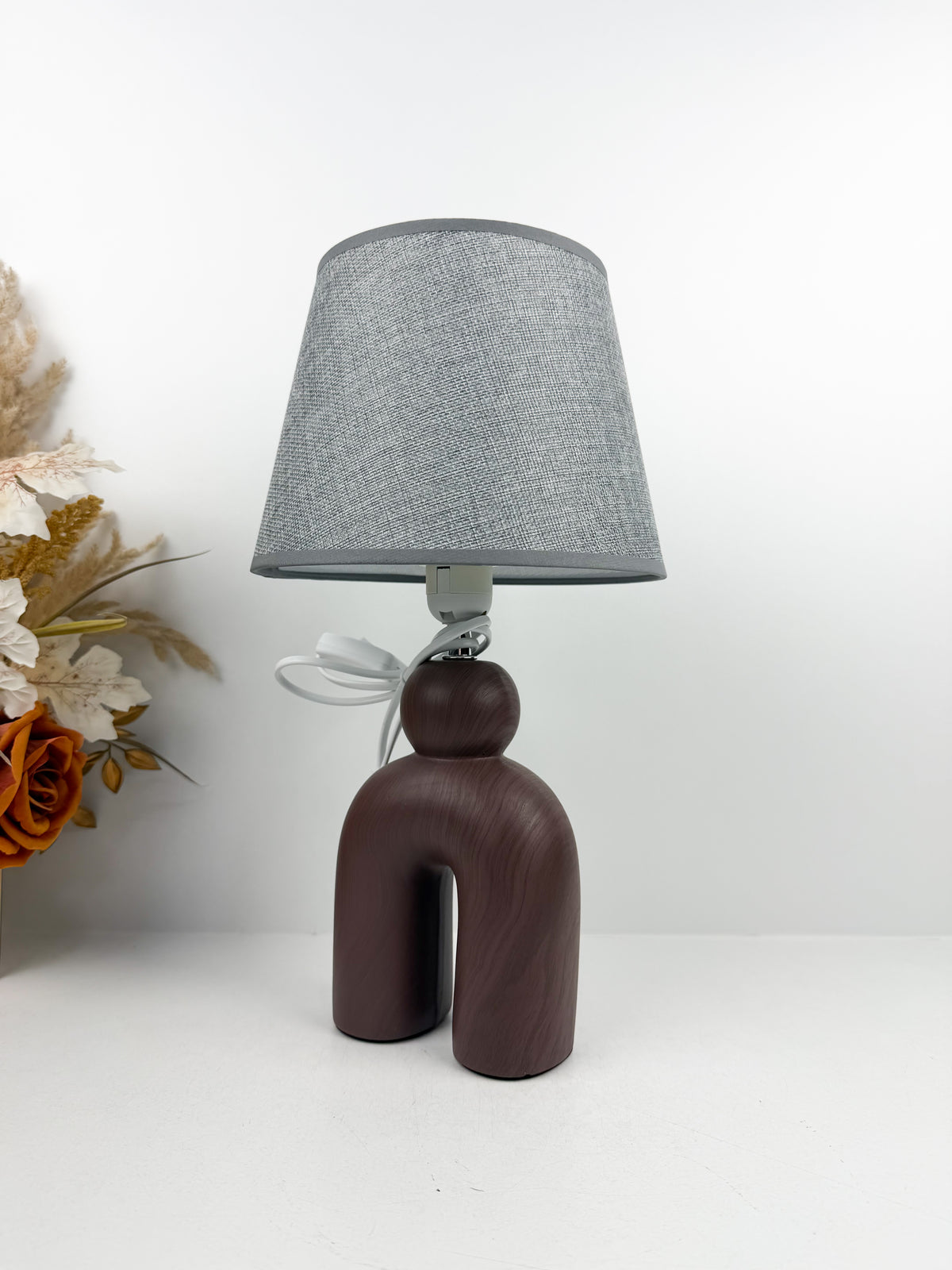 Lampe à Poser Sculpturale de pied en céramique mat d'un abat-Jour gris texturé.