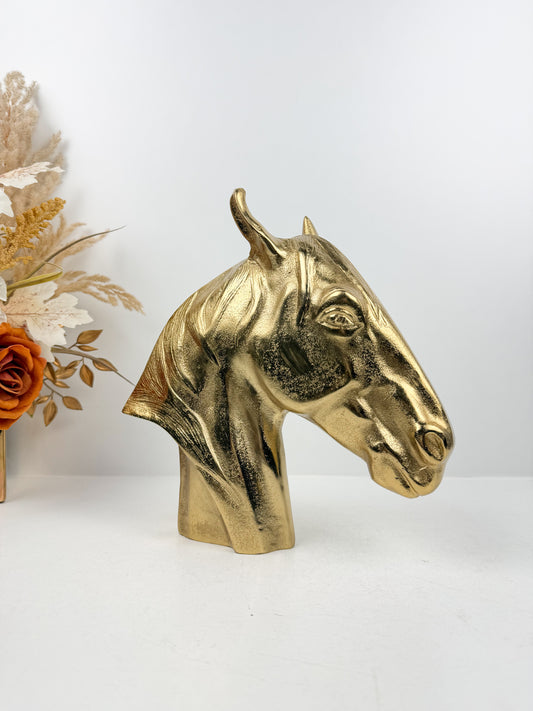 Sculpture décorative en métal doré brillant représentant une tête de cheval.