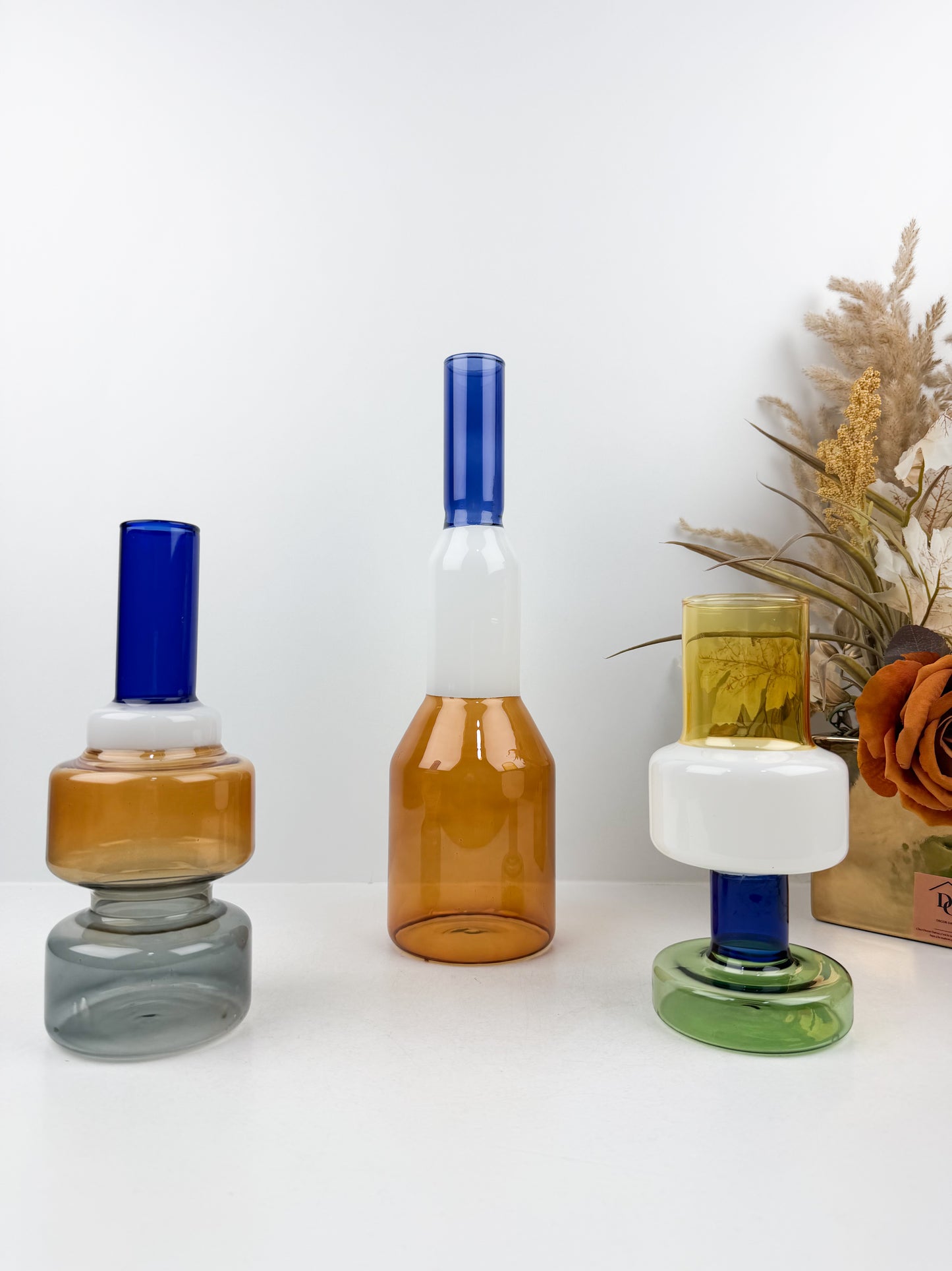 Trio de vases géométriques aux formes épurées et aux couleurs variées.
