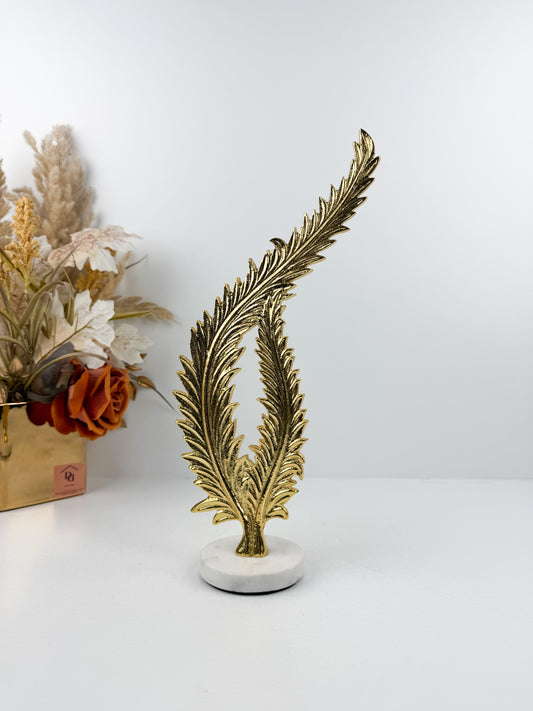 Sculpture décorative élégante représentant une feuille de fougère stylisée en métal doré.