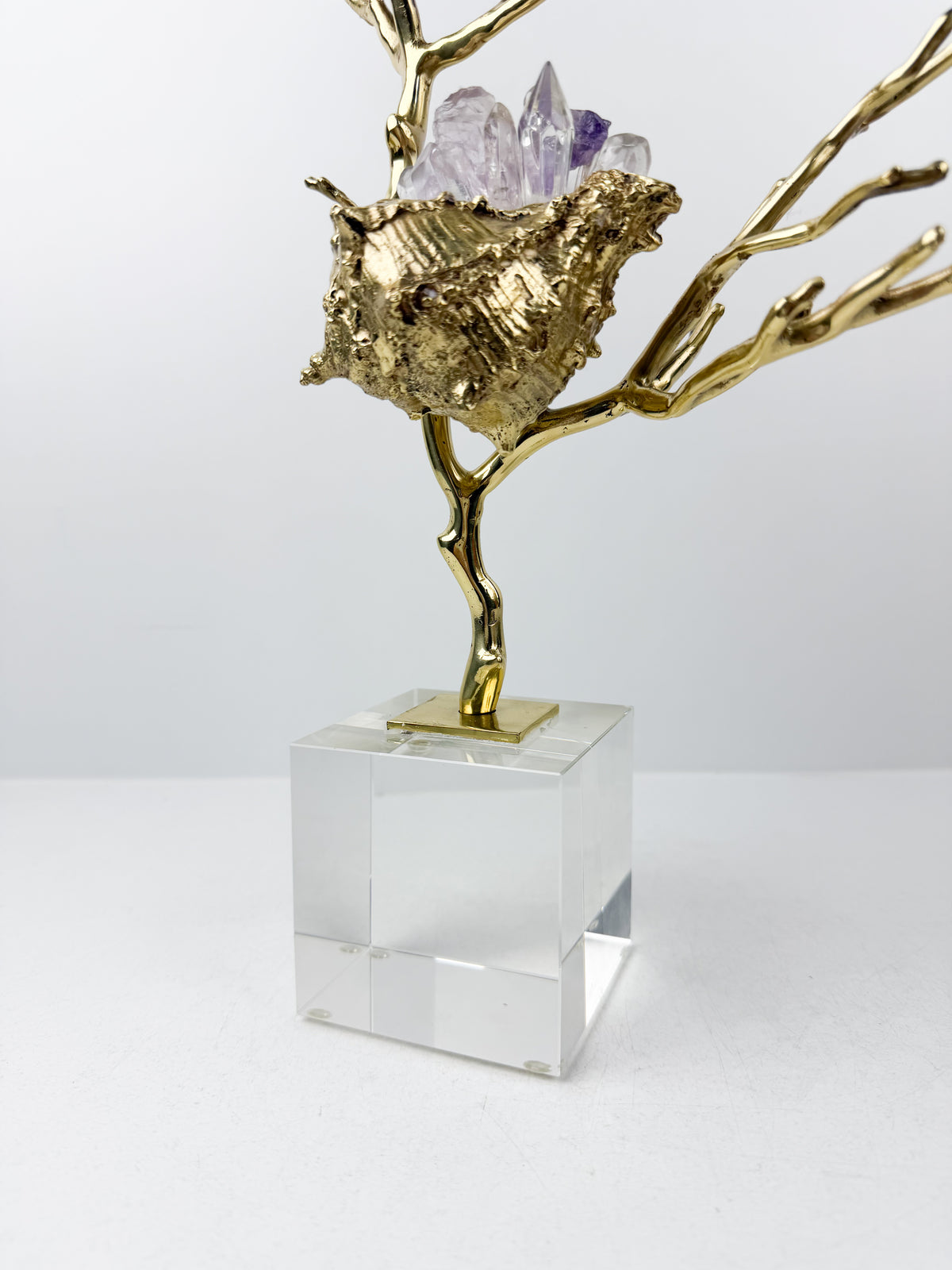 Sculpture de luxe de forme coquillage alliant l'élégance intemporelle du laiton doré aux reflets captivants des cristaux naturels.
