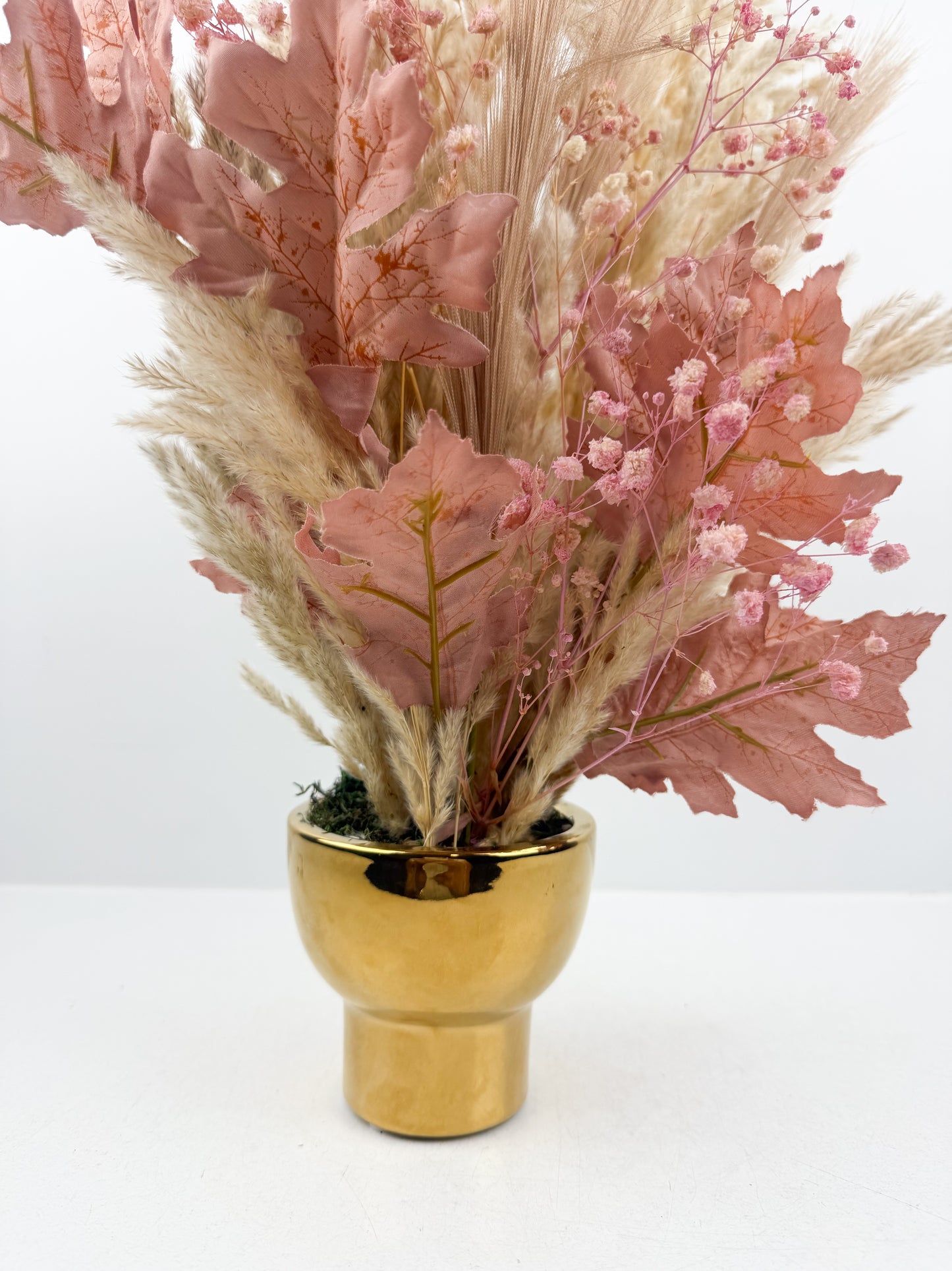 Fleurs séchées violet élégant arrangées dans un vase doré très chic.