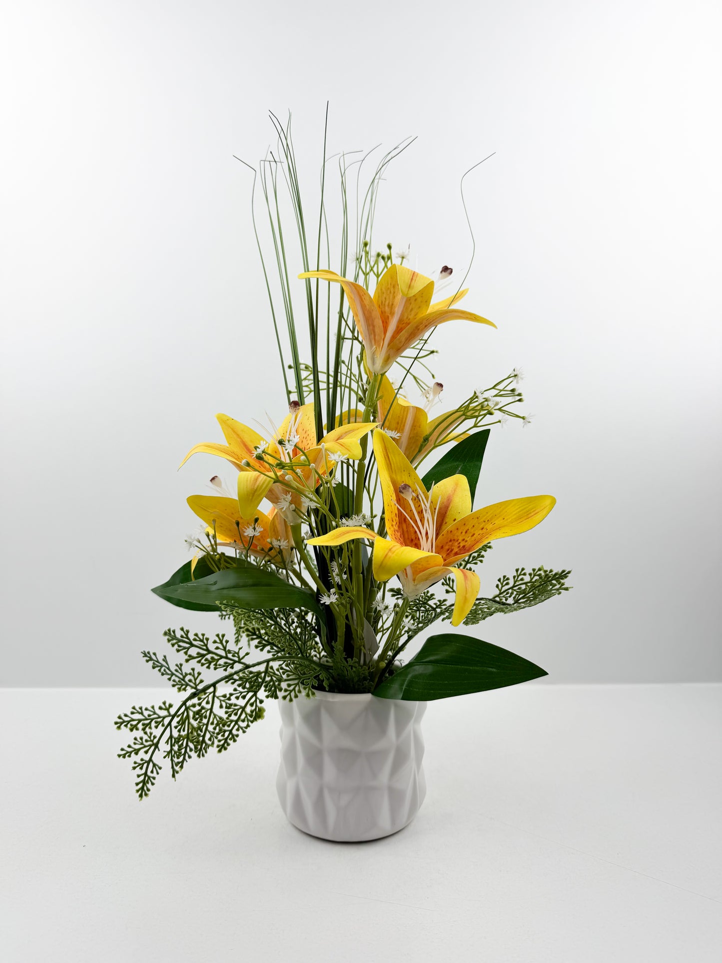 Fleurs artificielles jaunes délicates dans un élégant pot blanc en céramique de luxe.