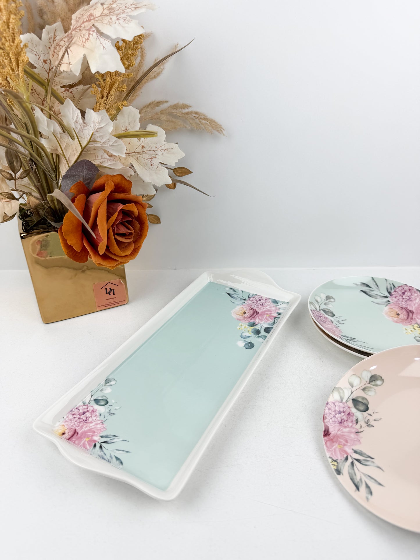 Grande assiette de service accompagnée de six assiettes assorties aux motifs floraux