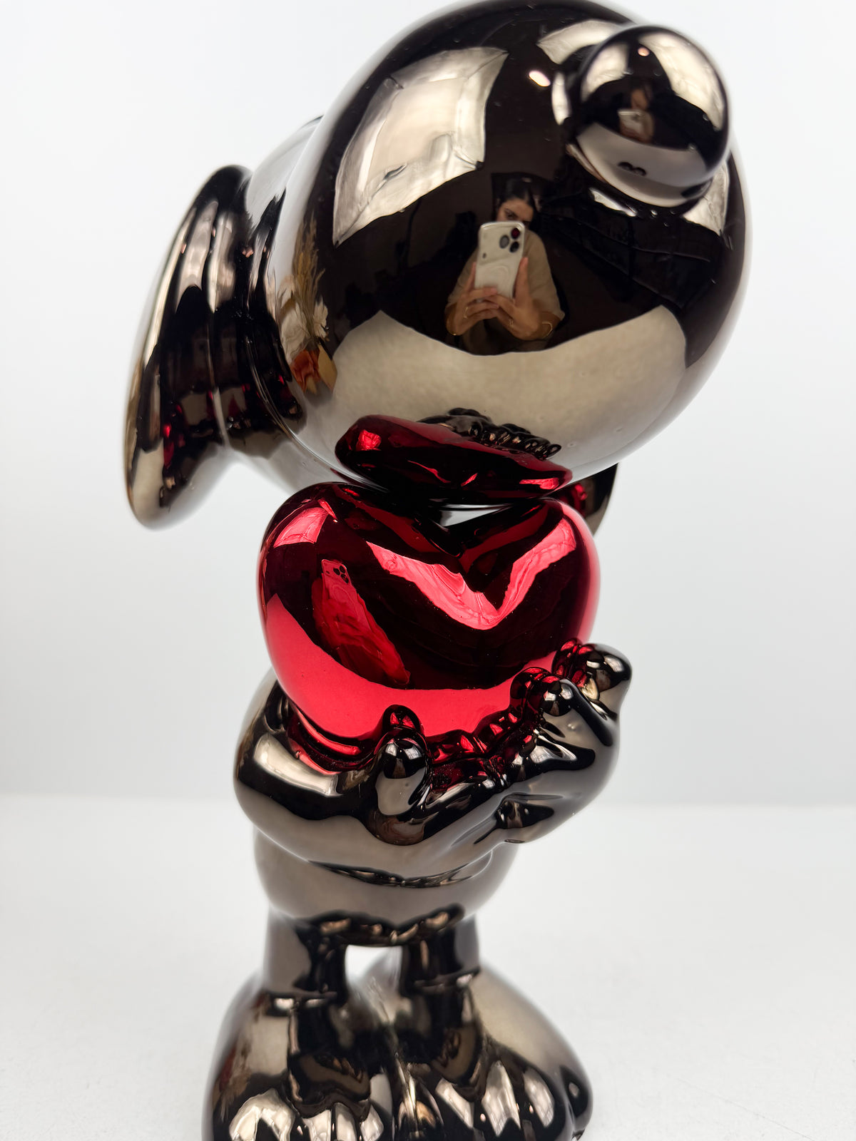 Figurine décorative représentant le célèbre personnage de Snoopy tenant un cœur.