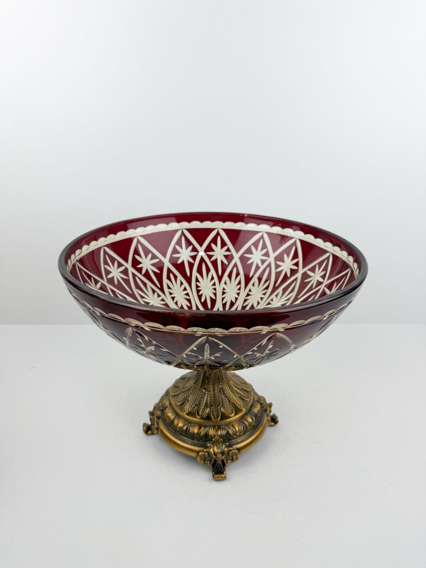 Présentoir en cristal rouge d'une grande finesse, reposant sur un pied en métal de qualité supérieure.